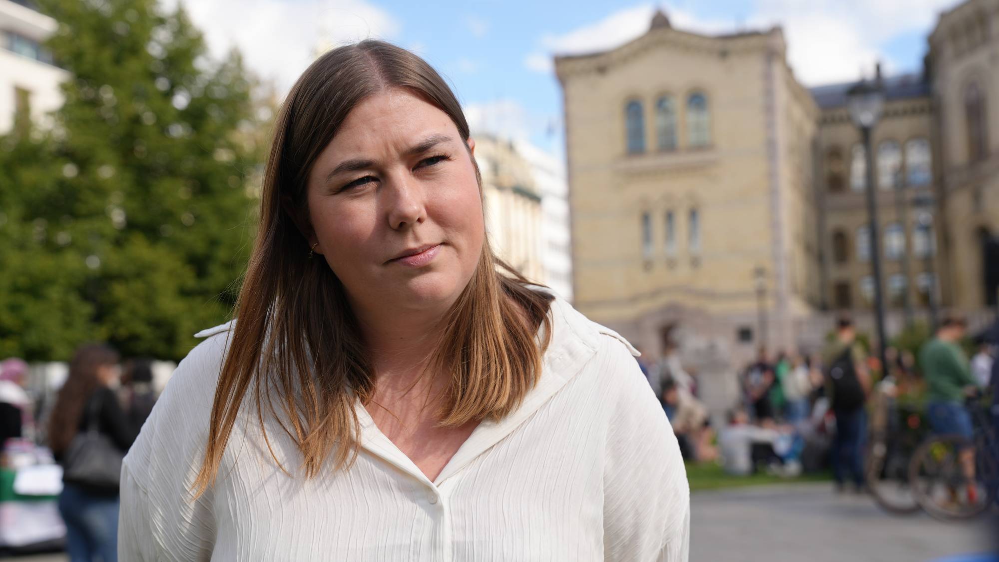 Kvinne med brunt hår og hvit skjorte