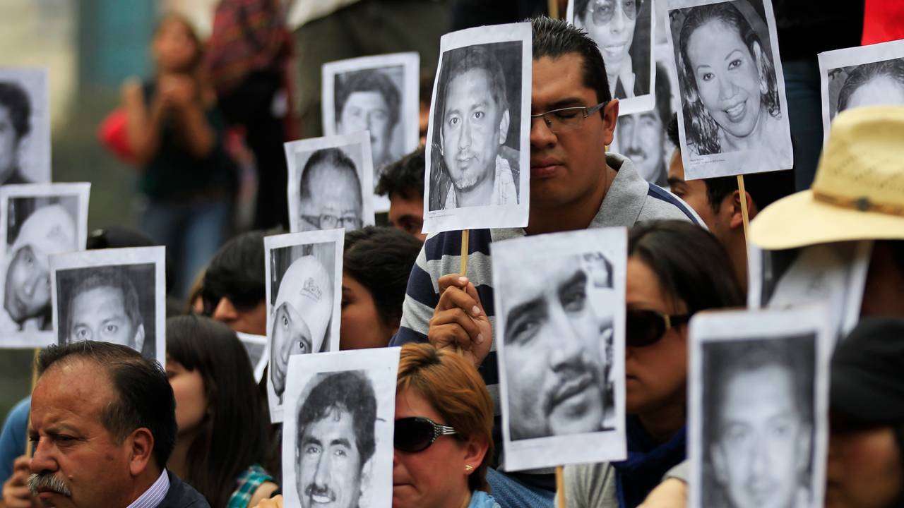 Meksikanske journalister holder bilder av kolleger som har blitt drept på jobb i en demonstrasjon i 2014. 