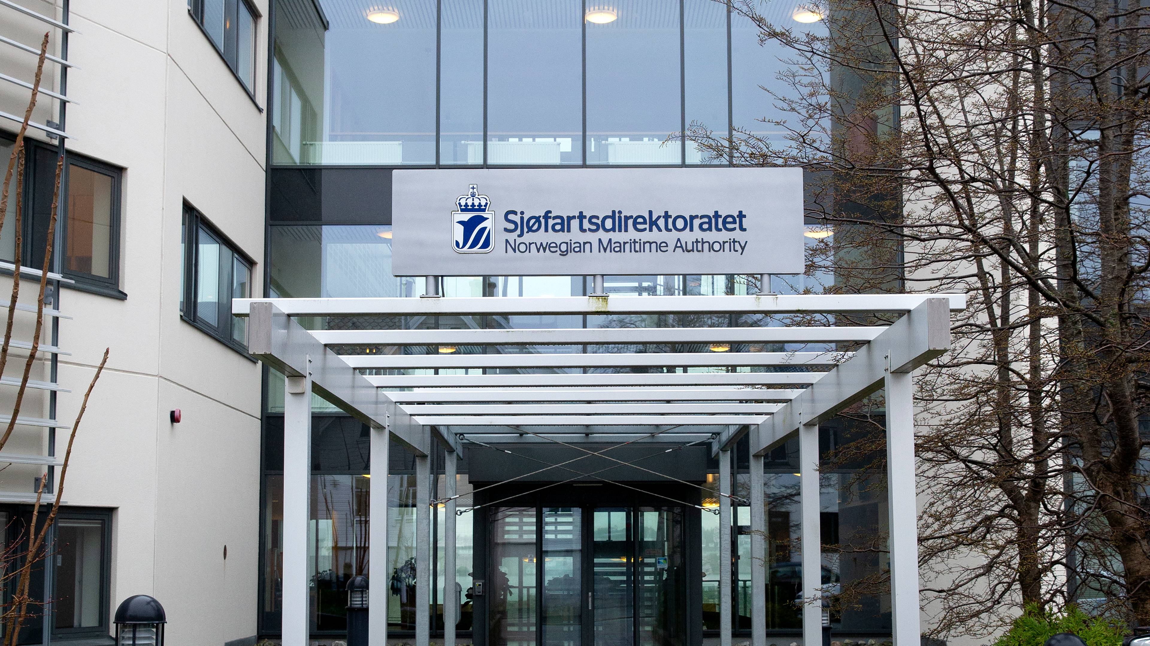 Inngangen til Sjøfartsdirektoratets kontor i Haugesund. Glassfasade foran, hvitt på sidene. Skilt over med tydelig logo og tittel på direktoratet.