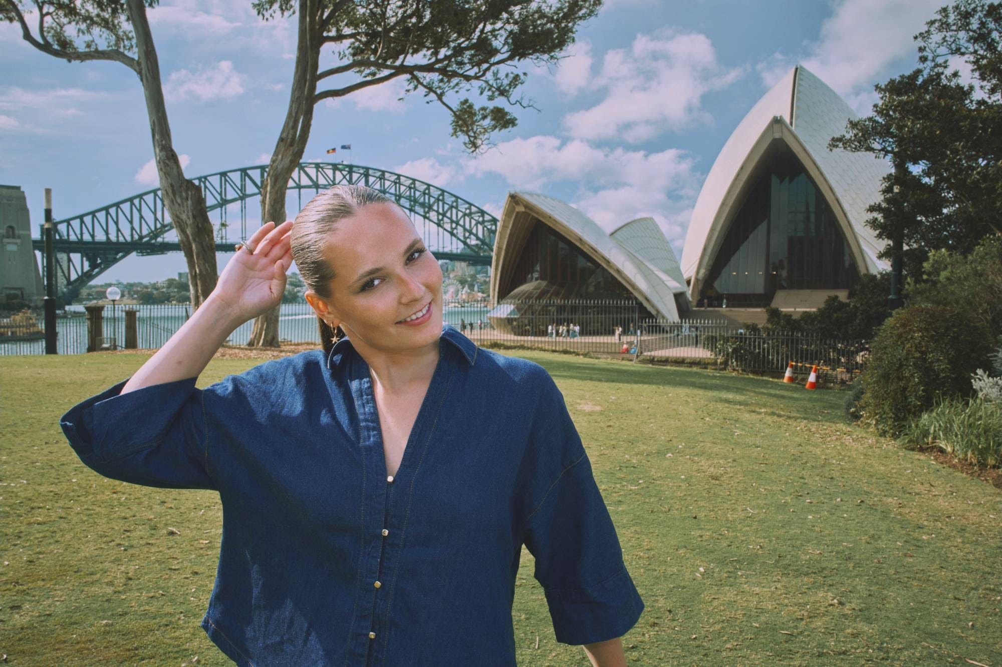 Prinsesse Ingrid Alexandra står foran operahuset i Sydney, hun justerer litt på hestehalen og smiler mot kamera.