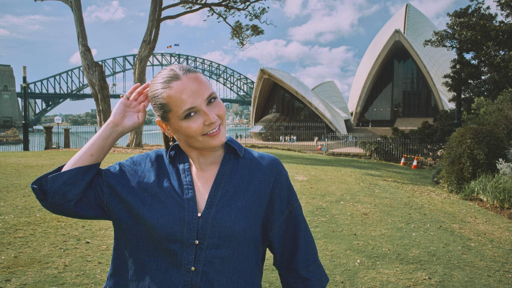 Prinsesse Ingrid Alexandra står foran operahuset i Sydney, hun justerer litt på hestehalen og smiler mot kamera.
