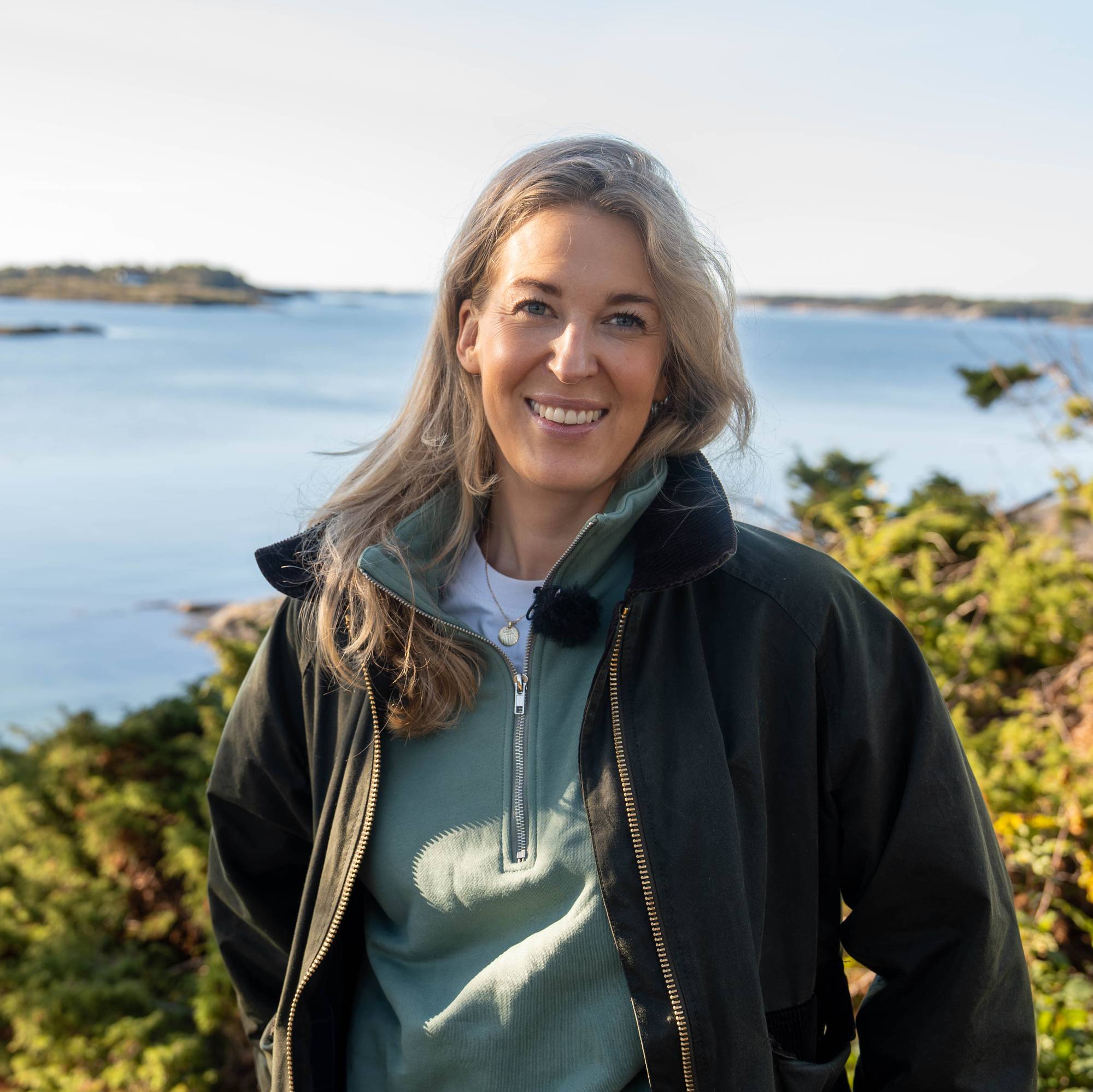 En kvinne står ved sjøen 