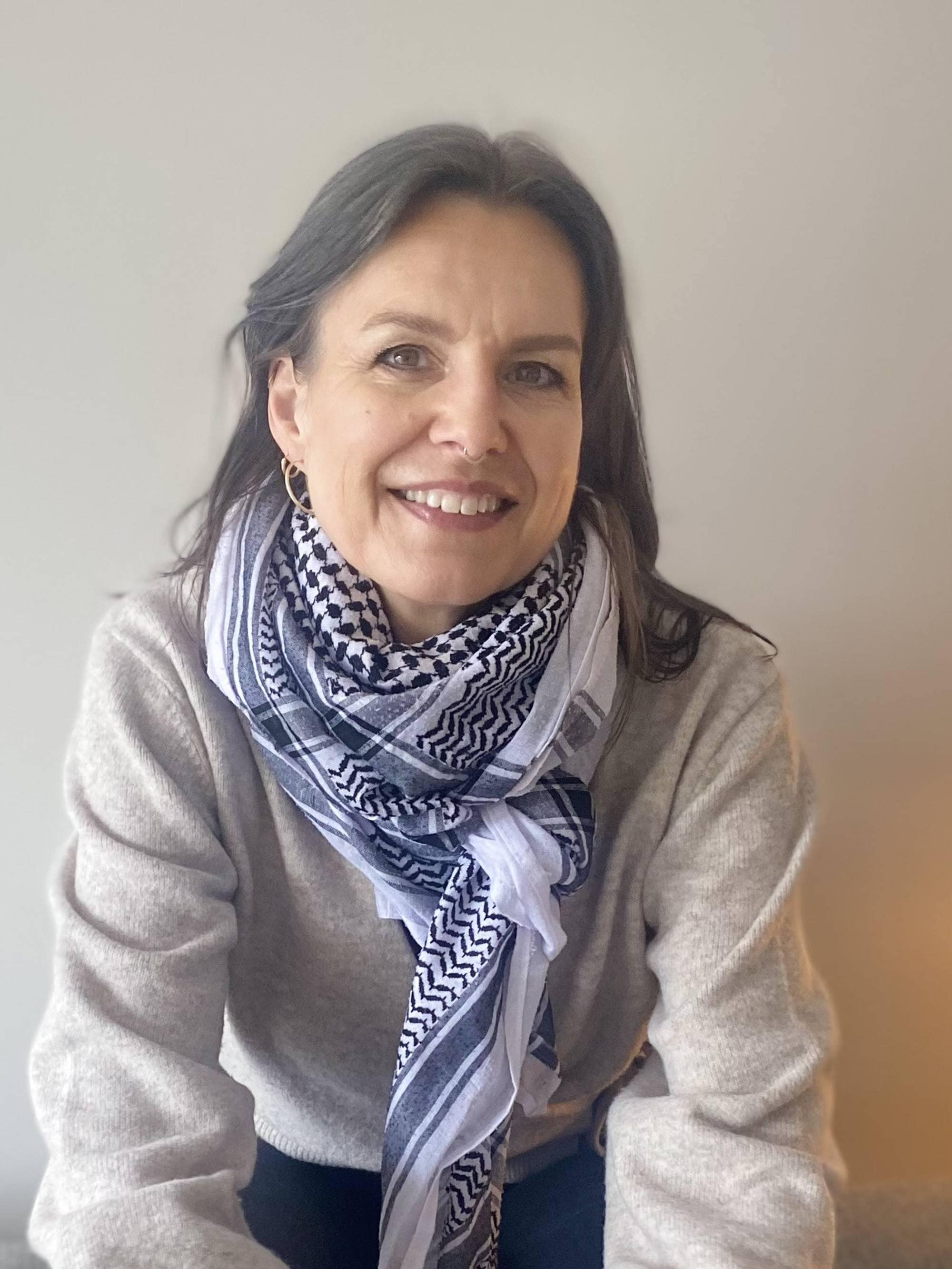 Lege Elisabeth Astrup sitter i en sofa og ser i kameraet.