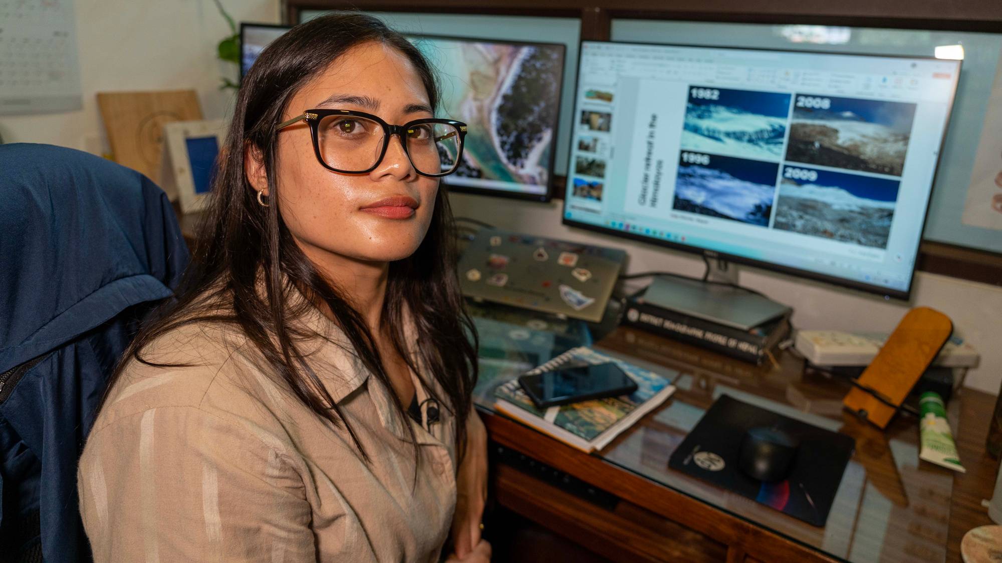 Kvinnelig nepalsk forsker ved datamaskin og ved bilde av Mt. Everest