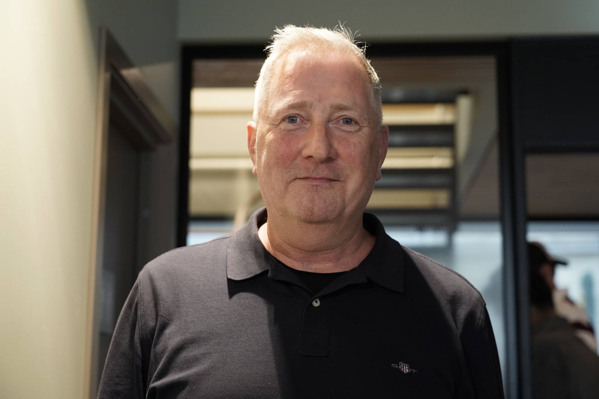  Martinus Røkkum, Parat - Halvnært bilde av mann i svart skjorte og grått hår.