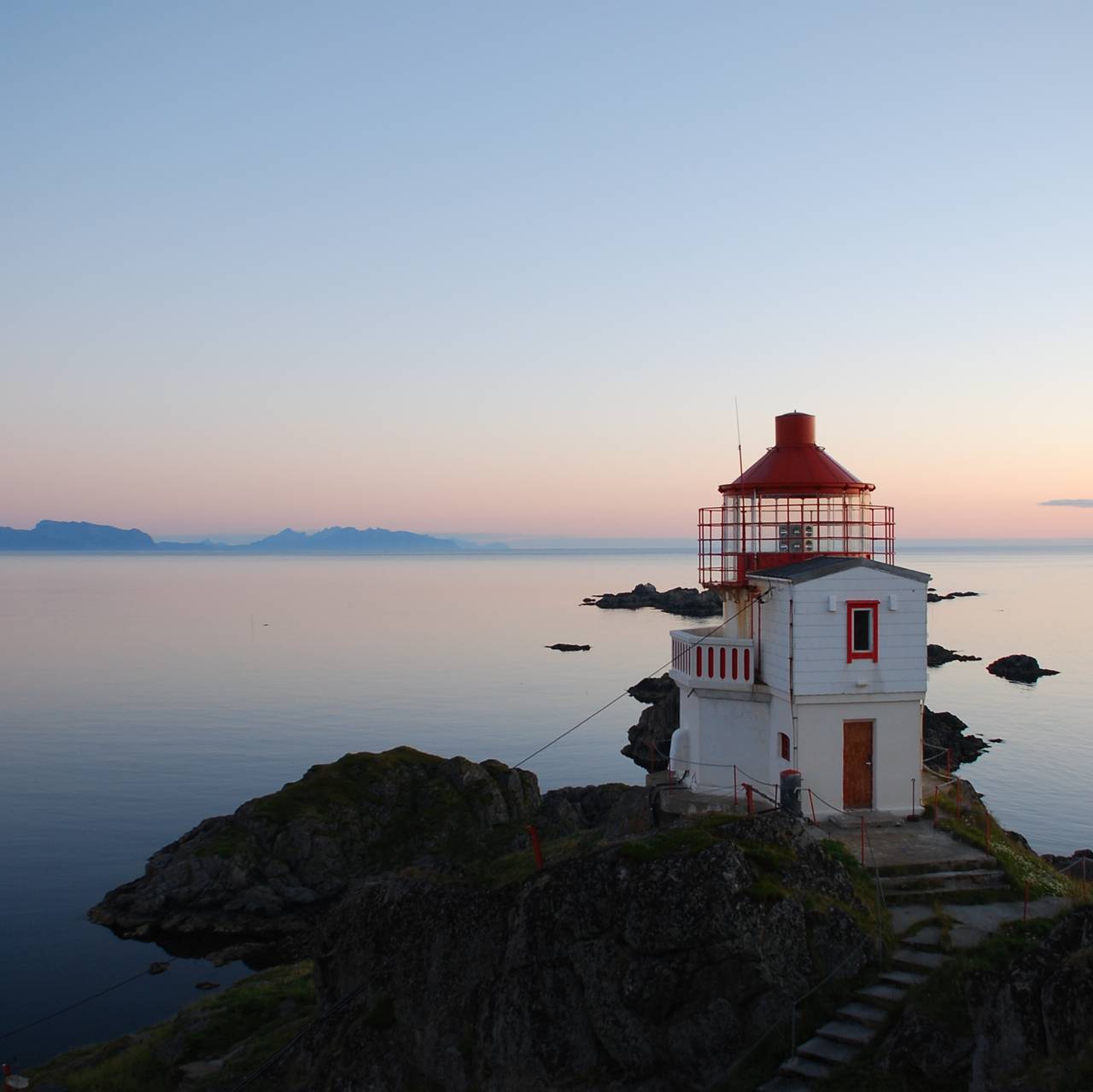 Et hvitt og rødt fyr ved havet - Litløy fyr utenfor Bø i Vesterålen