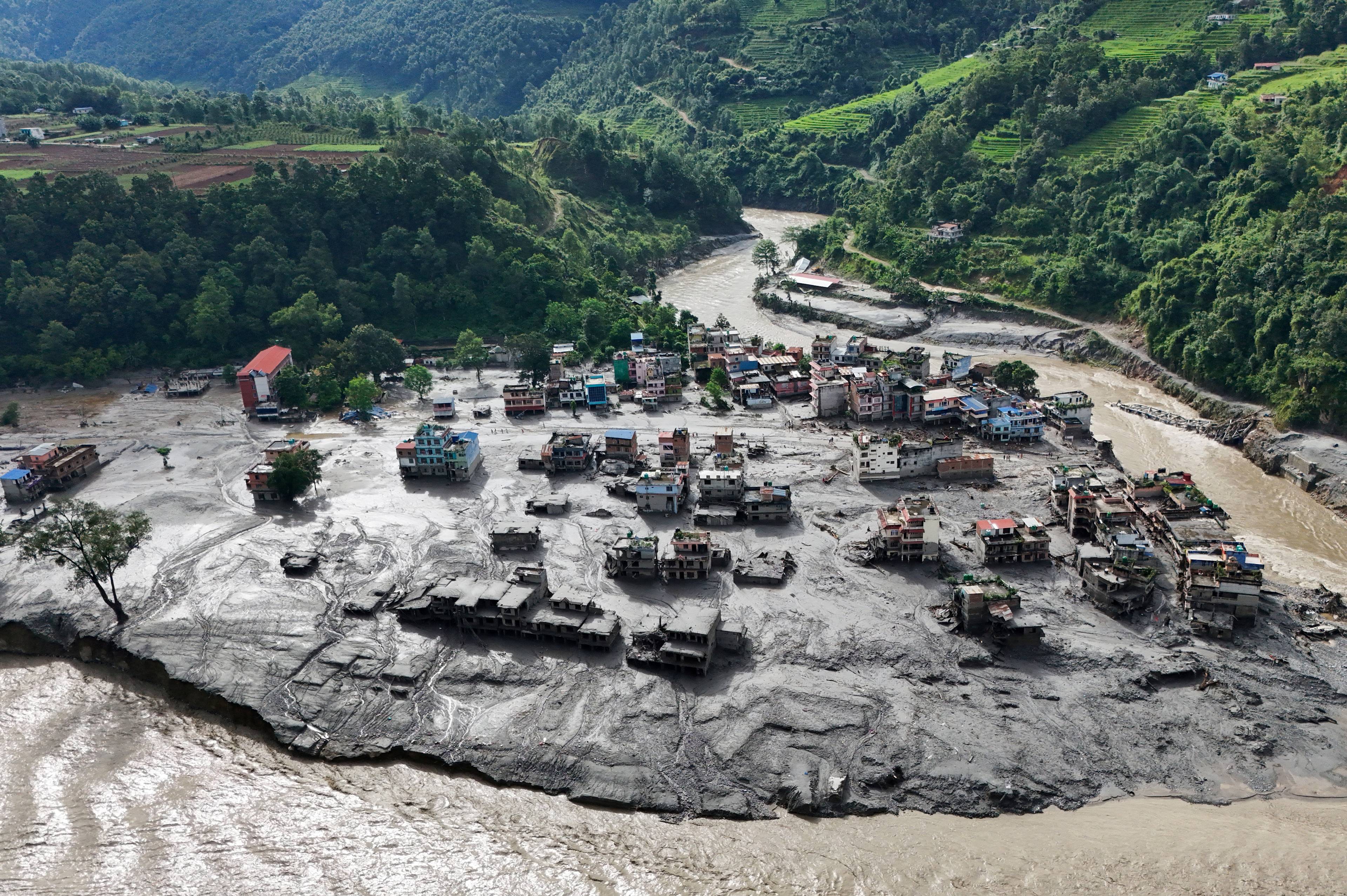 Flyfoto av et område preget av flom og store mengder jordmasser etter flomkatastrofe i Nepal. (Bildebeskrivelsen er laget av en KI-tjeneste)