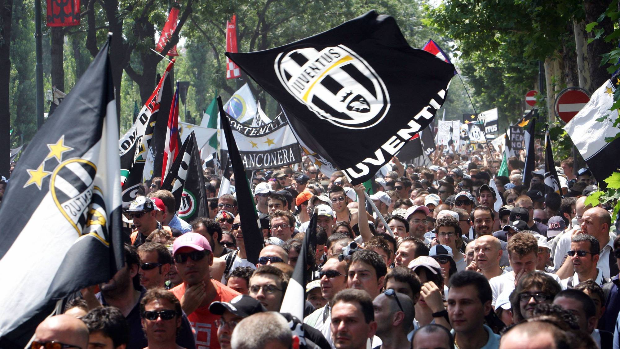 Supportere med Juventus-flagg samlet i en gate i Italia. (Bildebeskrivelsen er laget av en KI-tjeneste)