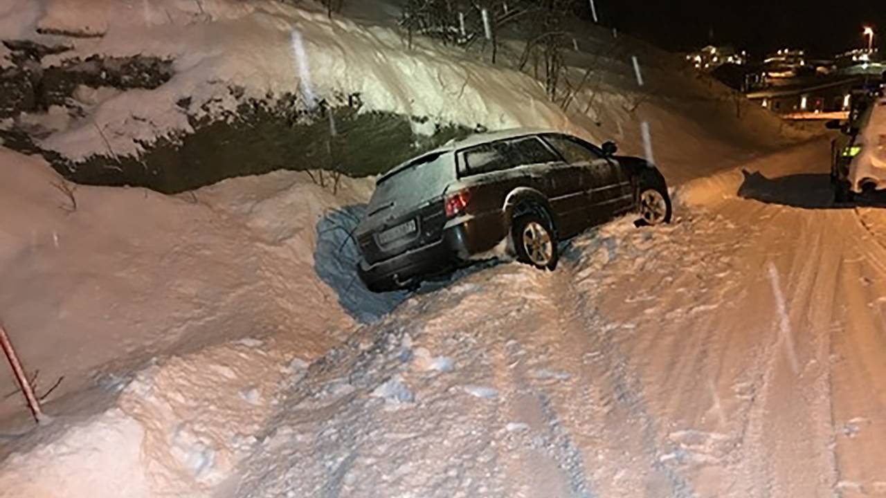 Tettere bilde av bil i grøfta ved snødekt vei