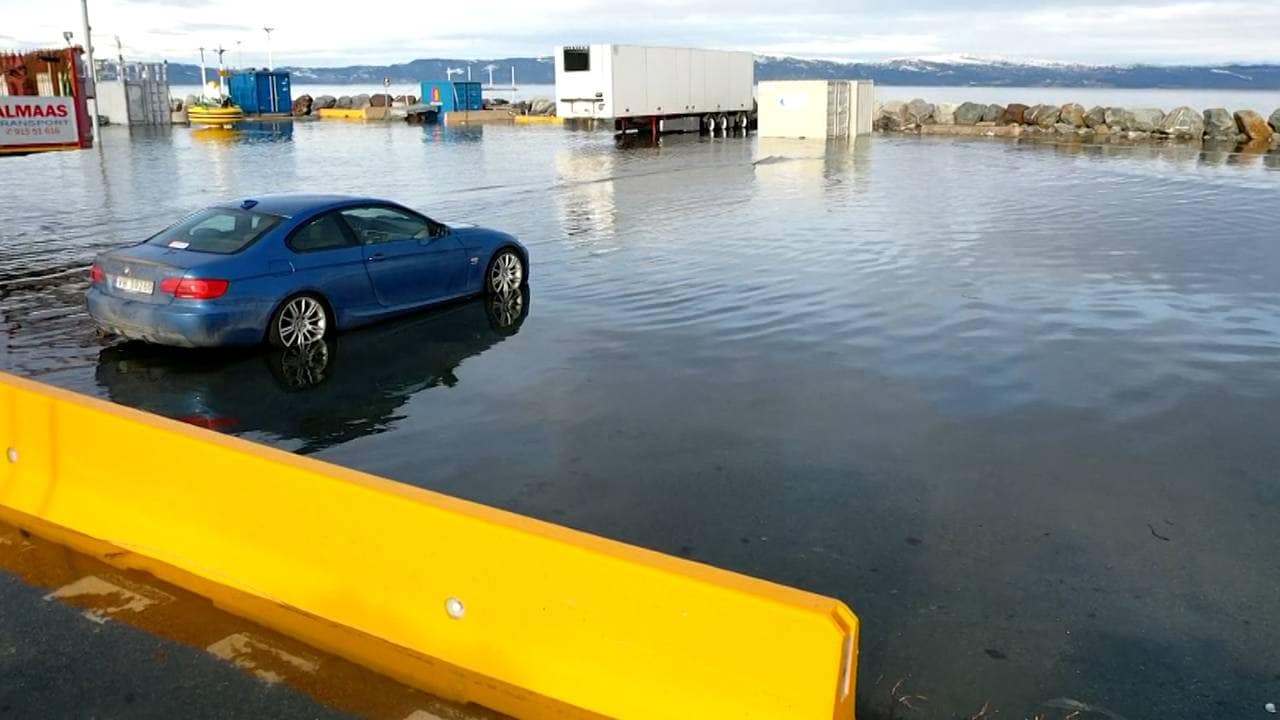 En bil står parkert på piren i Trondheim, med vann oppover dekkene.