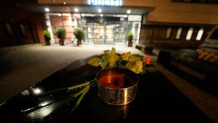 A photo of ⁤the ​police station in Stavanger ‍with flowers and candles placed outside in tribute to the fallen officer.