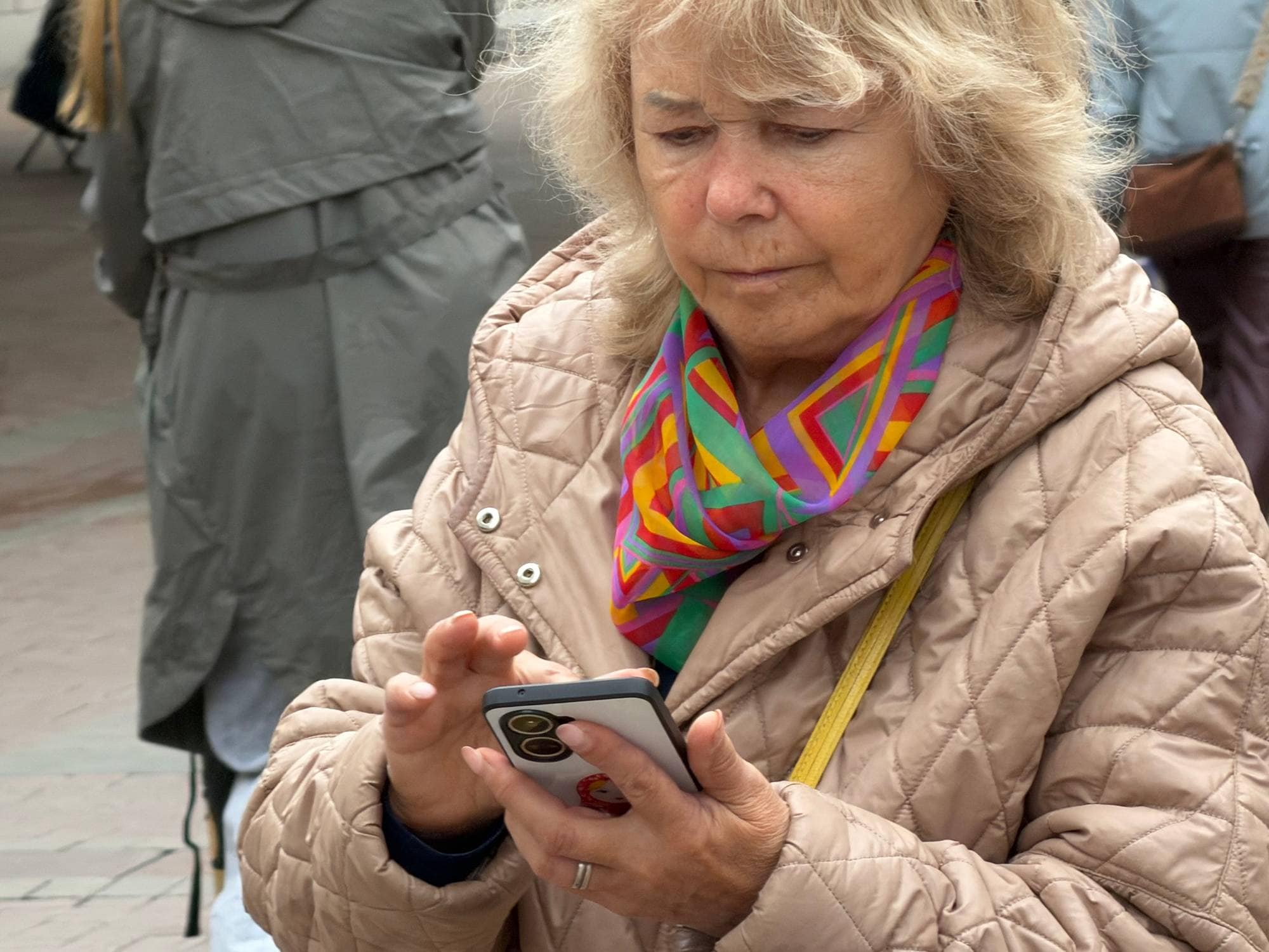 En kvinne er på telefonen sin i Moskva. Hun er utendørs og har på en boblejakke. 