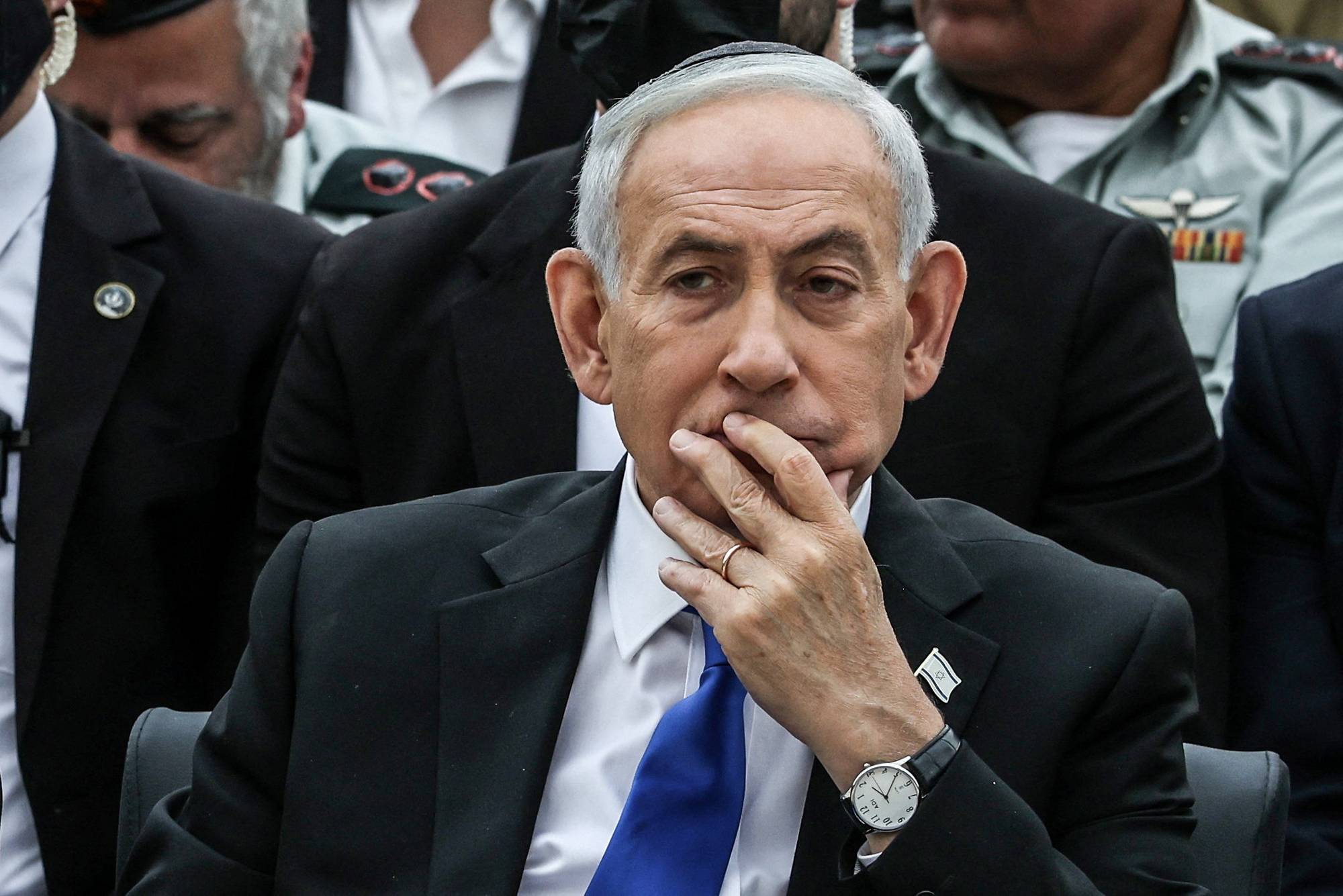 Statsminister Benjamin Netanyahu sitter med hånden til munnen. Han har på seg dress, hvit skjorte og blått slips. Netanyahu bærer en klokke på venstre håndledd. (Bildebeskrivelsen er laget av en KI-tjeneste)