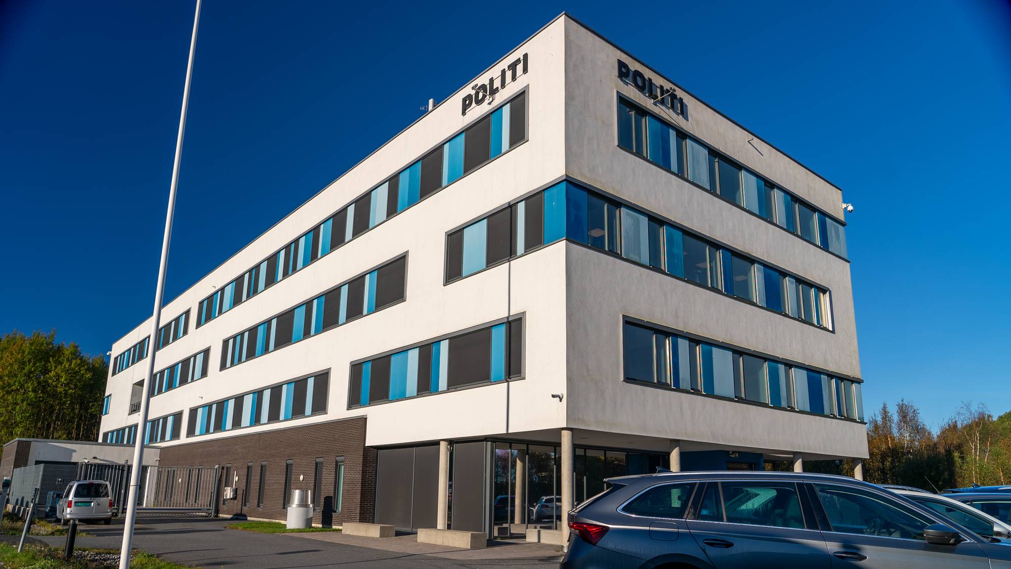 Bilde av hus med biler foran. 