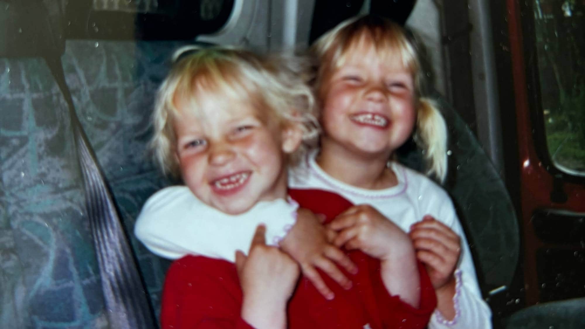 Celine og Cathrine som små, holder rundt hverandre og smiler bredt.