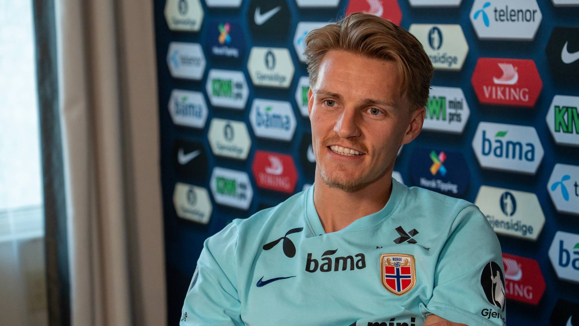 Norsk fotballspiller på et hotellrom blir intervjuet