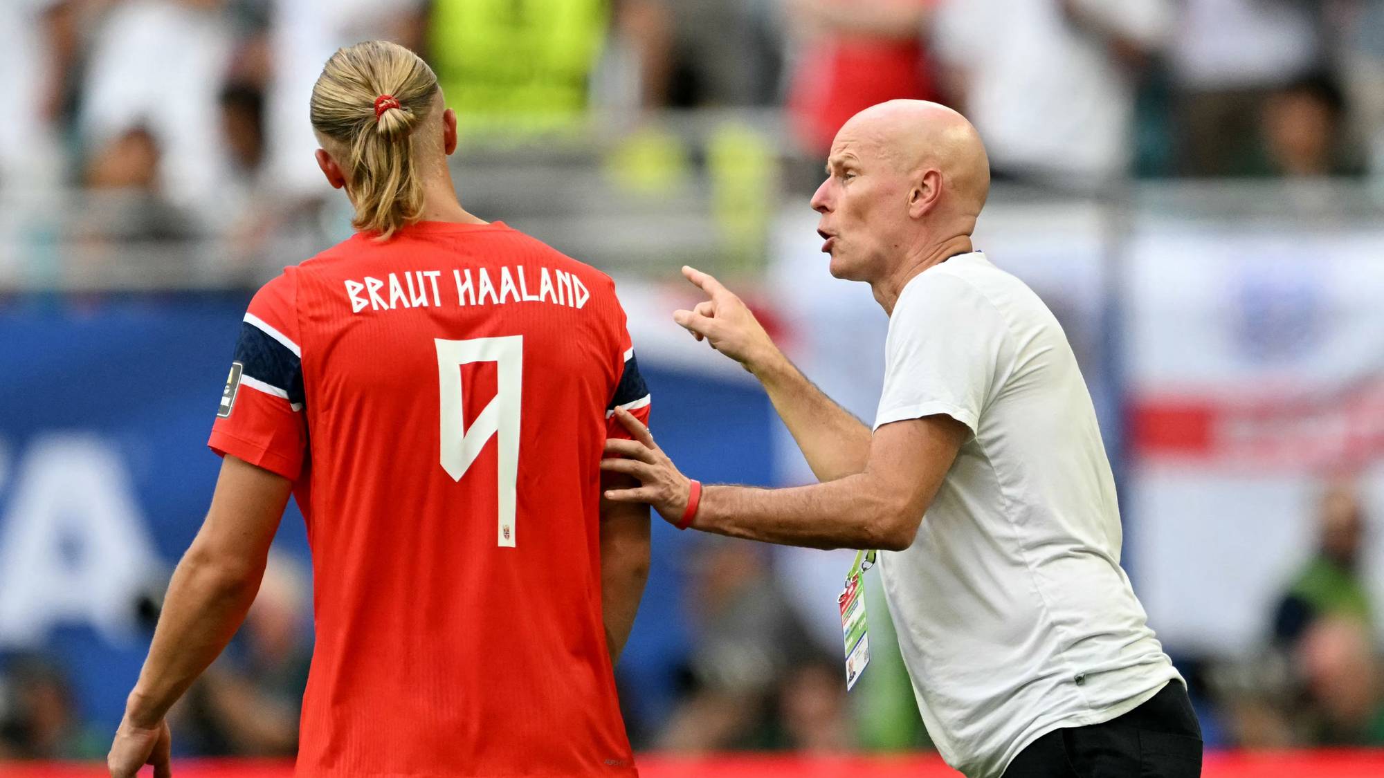 Ståle Solbakken snakker med Erling Braut Haaland på fotballbanen. (Bildebeskrivelsen er laget av en KI-tjeneste)