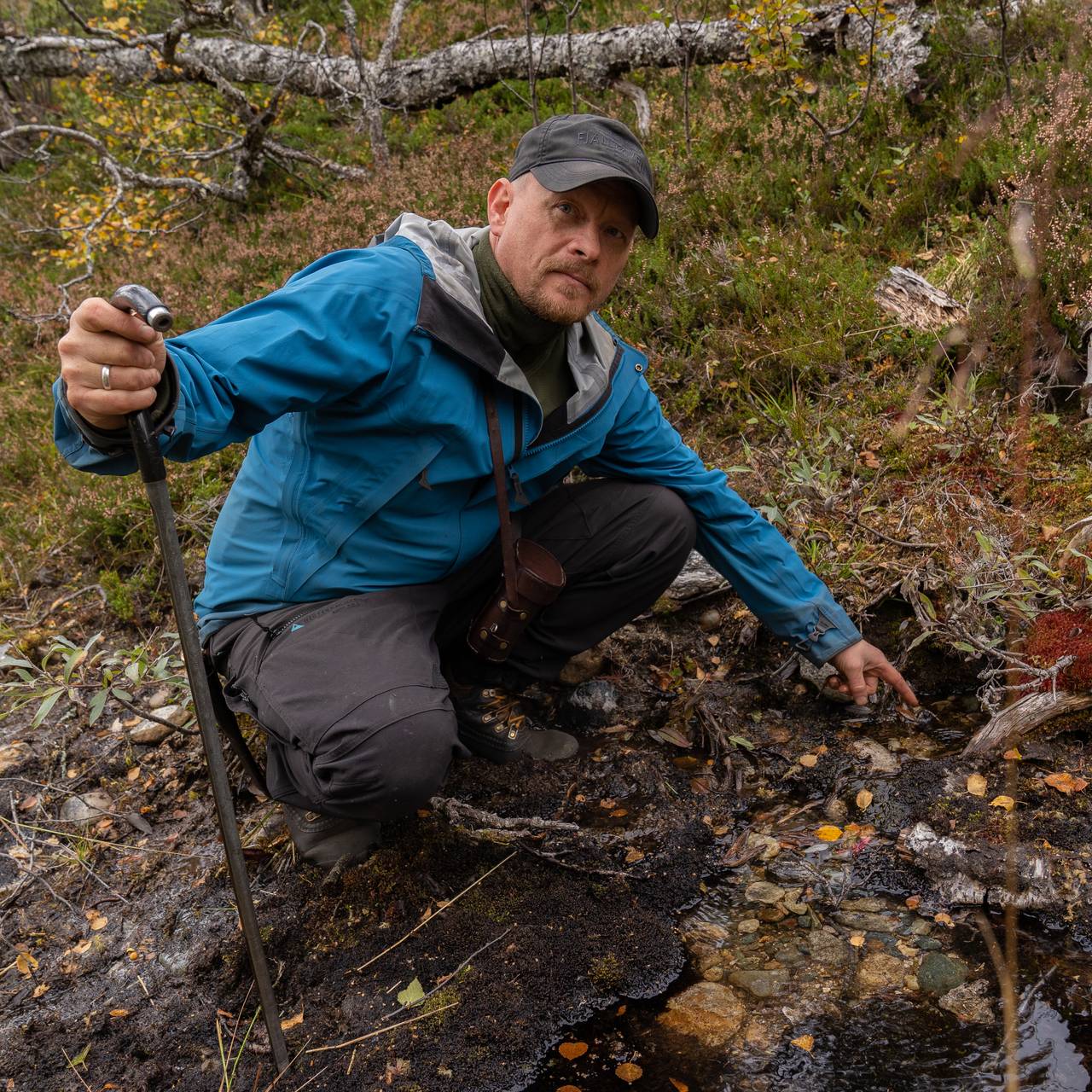 Mann peker på vannkilde