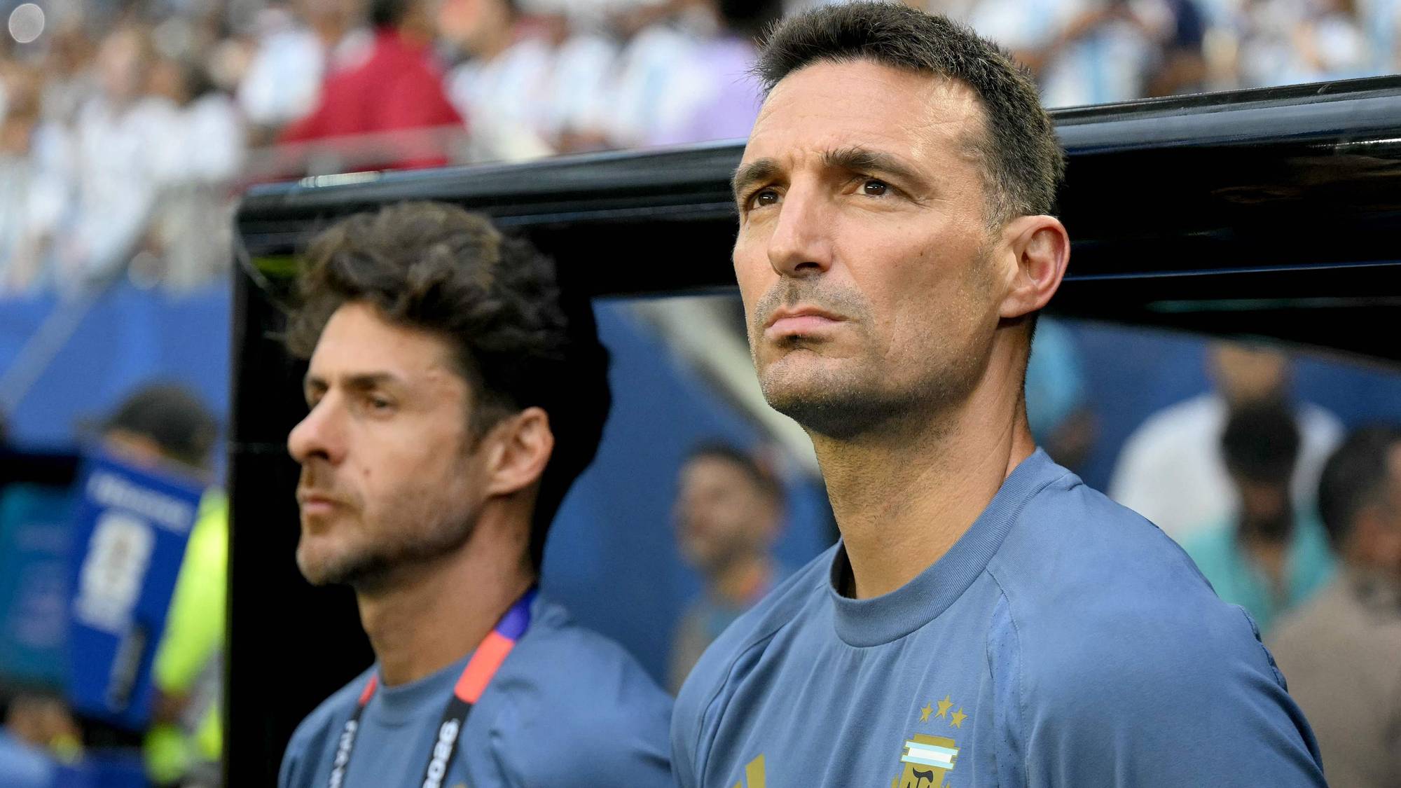 Argentinas landslagstrener Lionel Scaloni og assistent på sidelinjen under en fotballkamp. (Bildebeskrivelsen er laget av en KI-tjeneste)