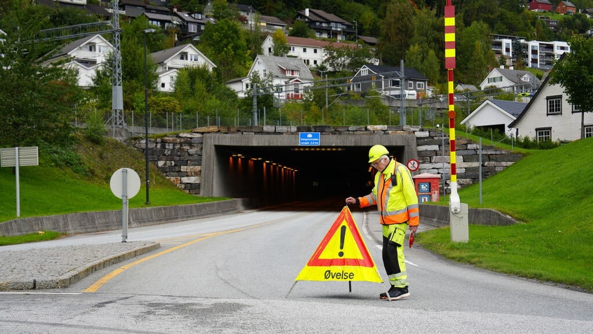 ein gulkledd mann bak eit skilt med ordet "øving" på FOTO: Tale Hauso/NRK