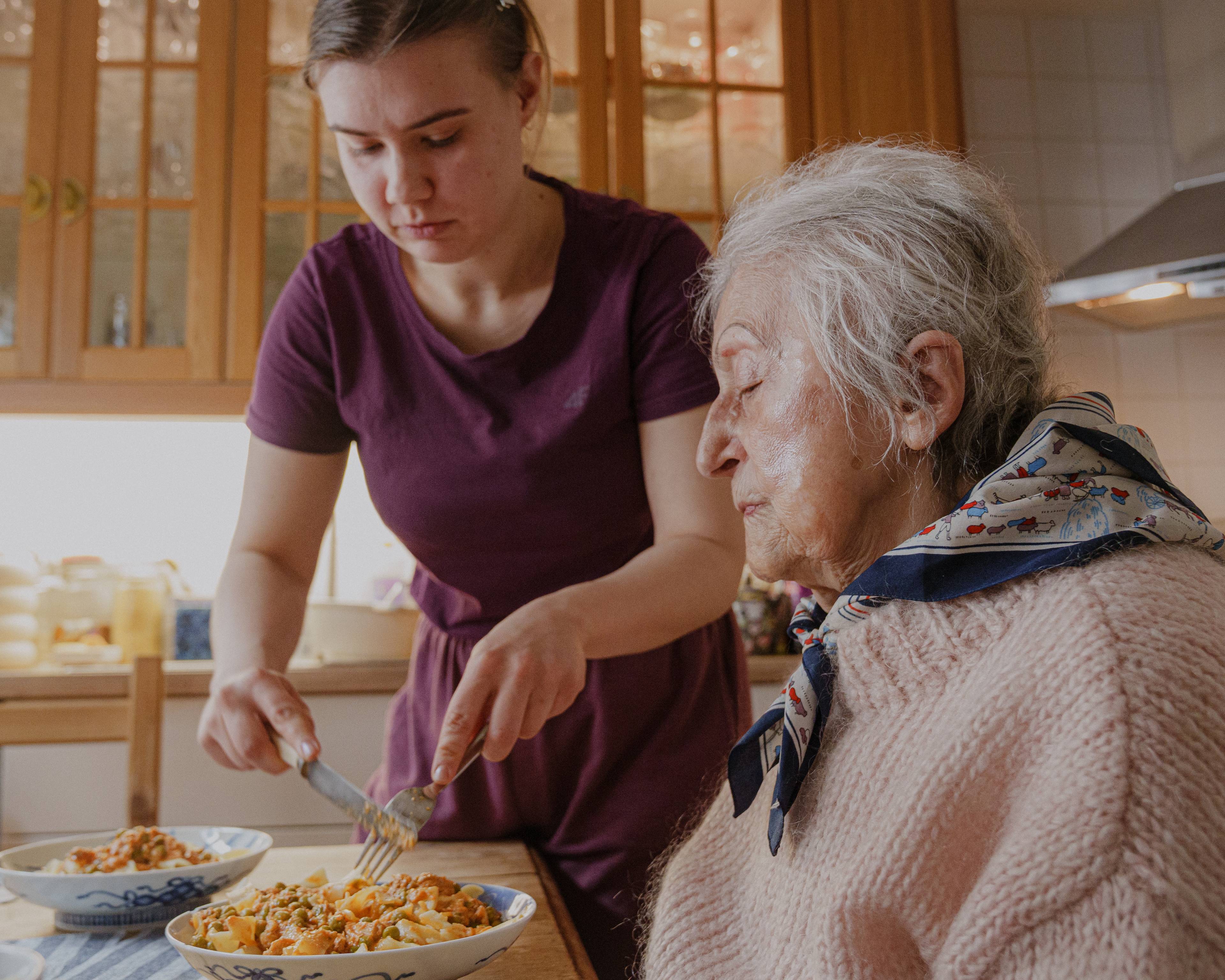 Celina, en ung kvinne, serverer mat til Magdalena
