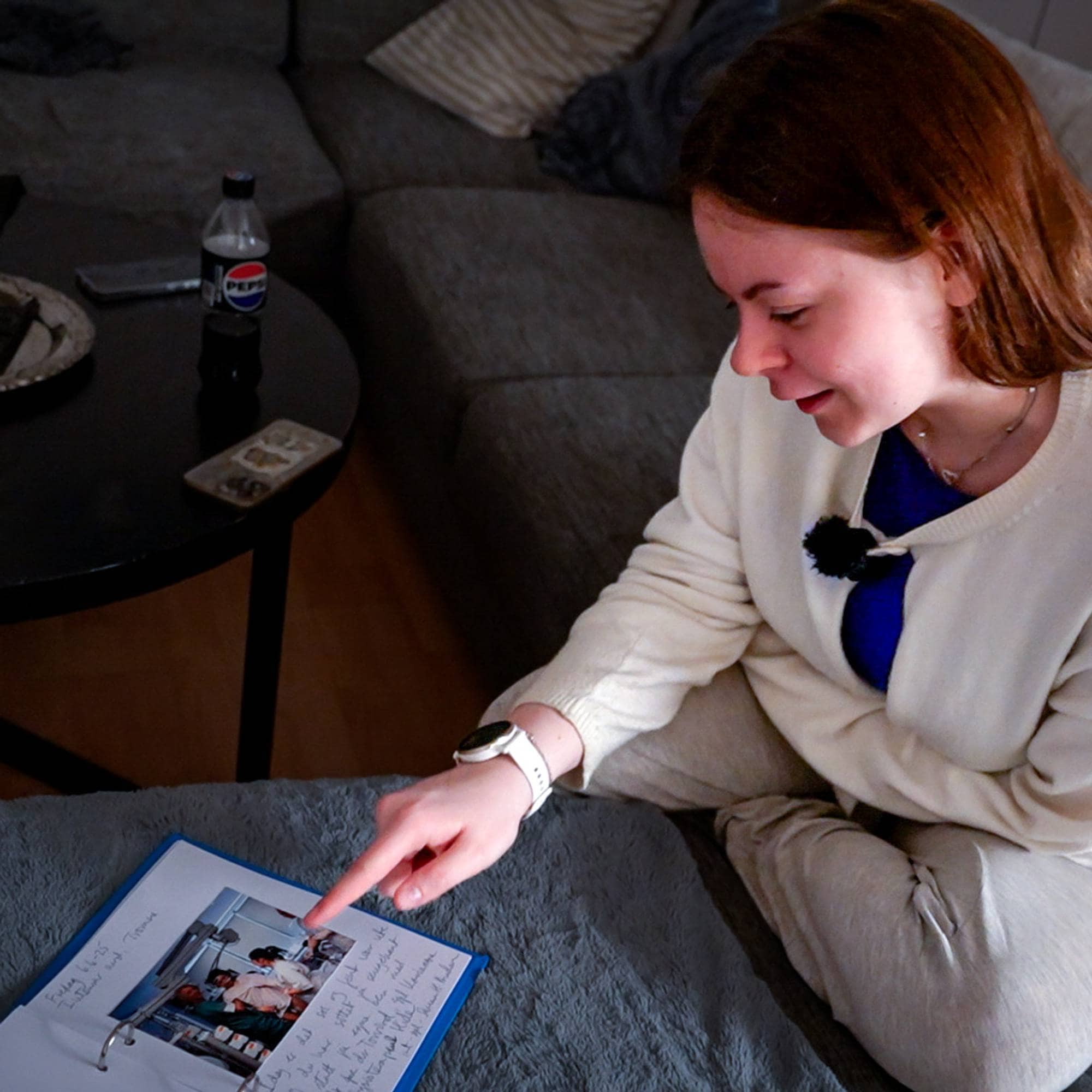 Ung dame sitter i en sofa og forteller