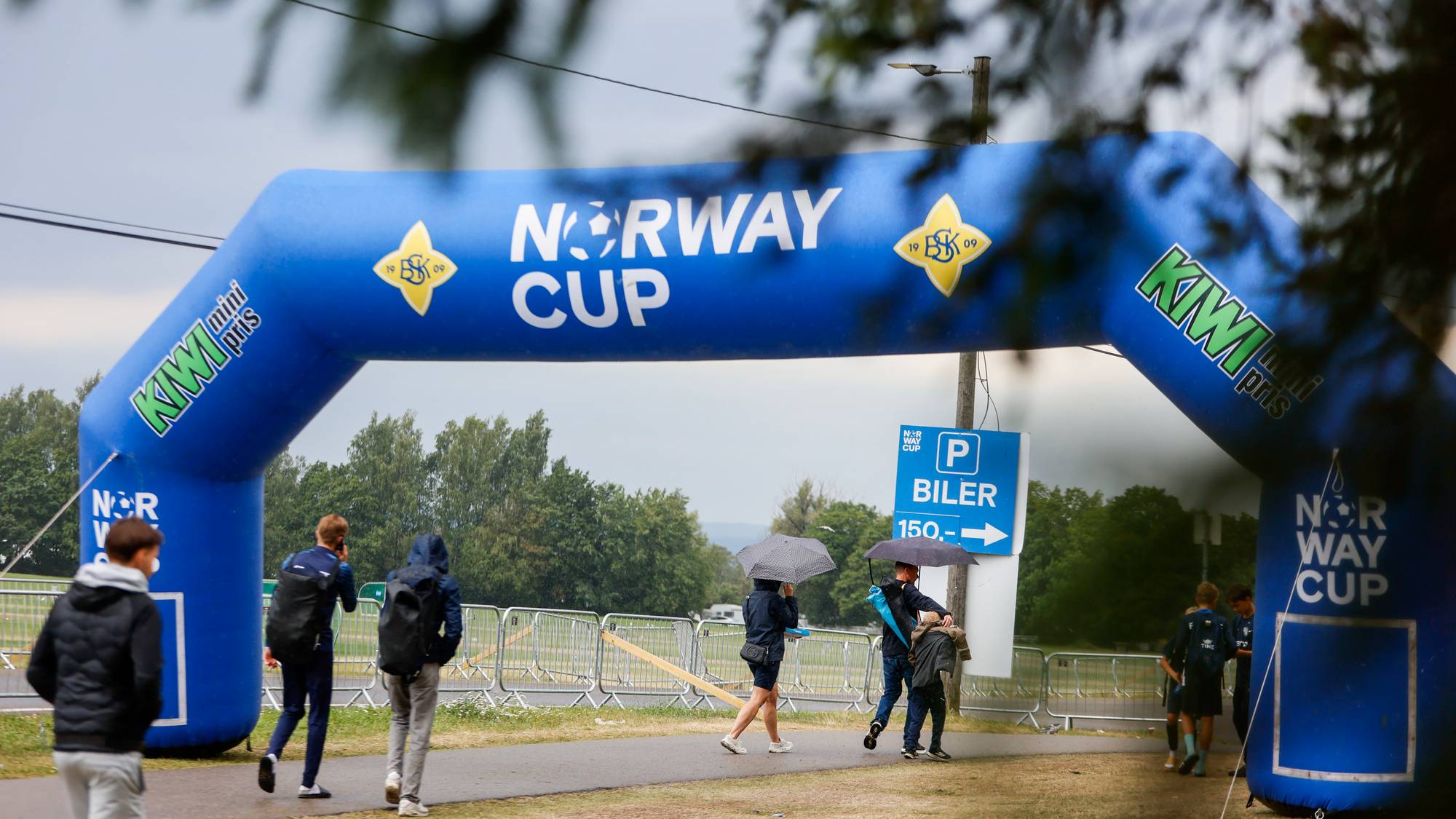 Personer går under en oppblåsbar portal for Norway Cup på Ekebergsletta i Oslo.