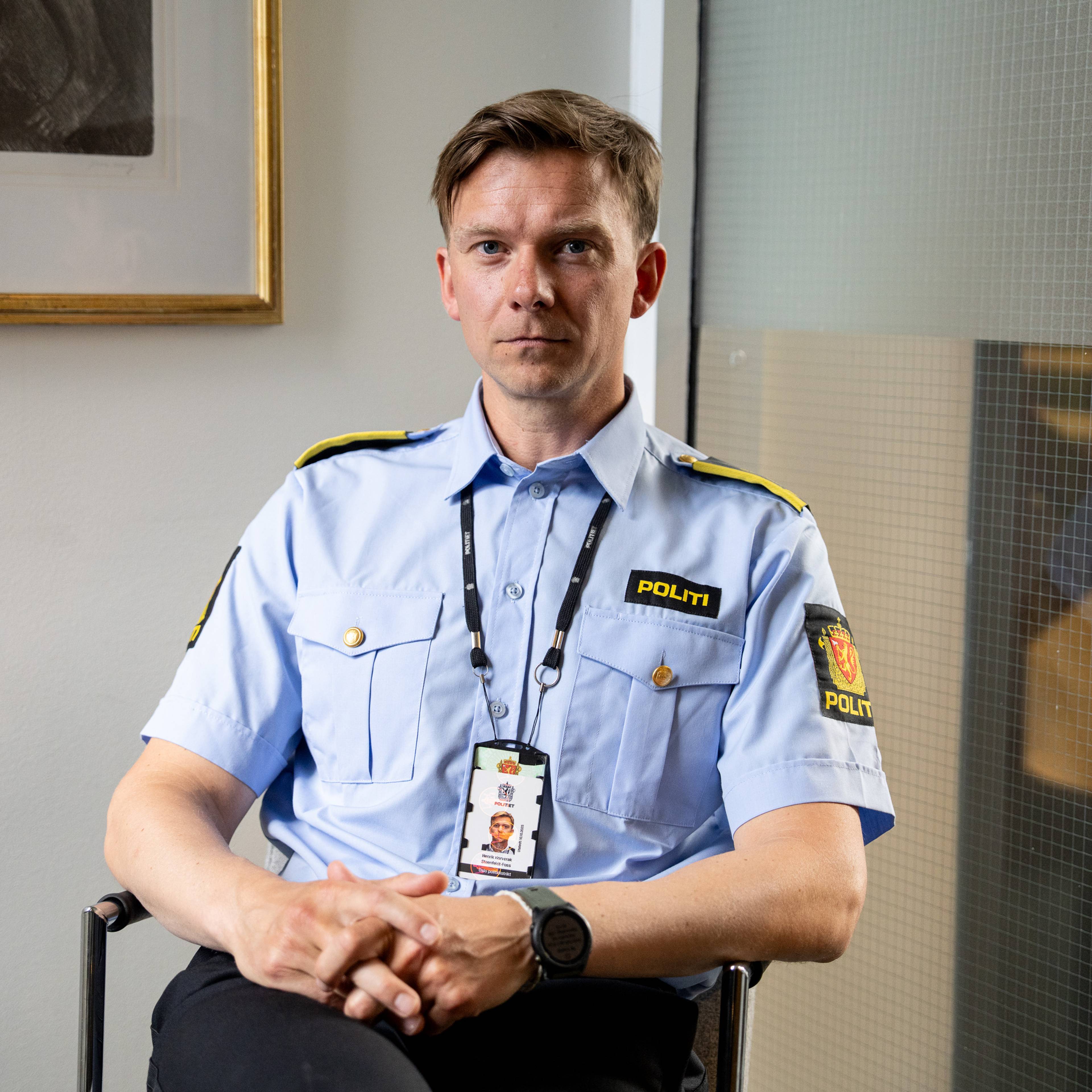 politiadvokat Henrik Horverak Steenfeldt-Foss i Oslo politidistrikt sitter på en stol. Han ser rett i kamera og har kort blondt hår. Han har politiuniform på seg og politiets ID-kort rundt halsen.