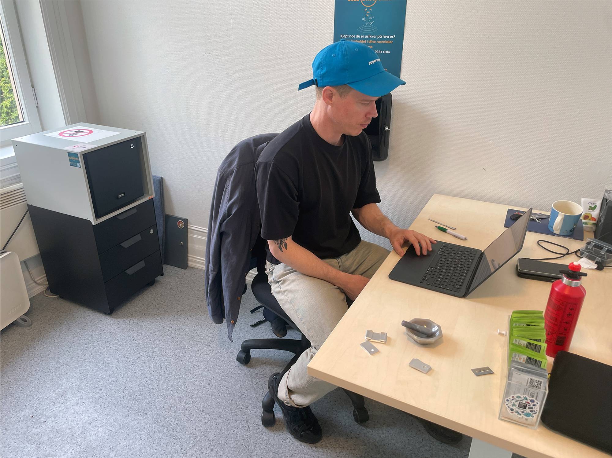 en person med blå hatt som jobber på en laptop (Bildebeskrivelsen er laget av en KI-tjeneste)
