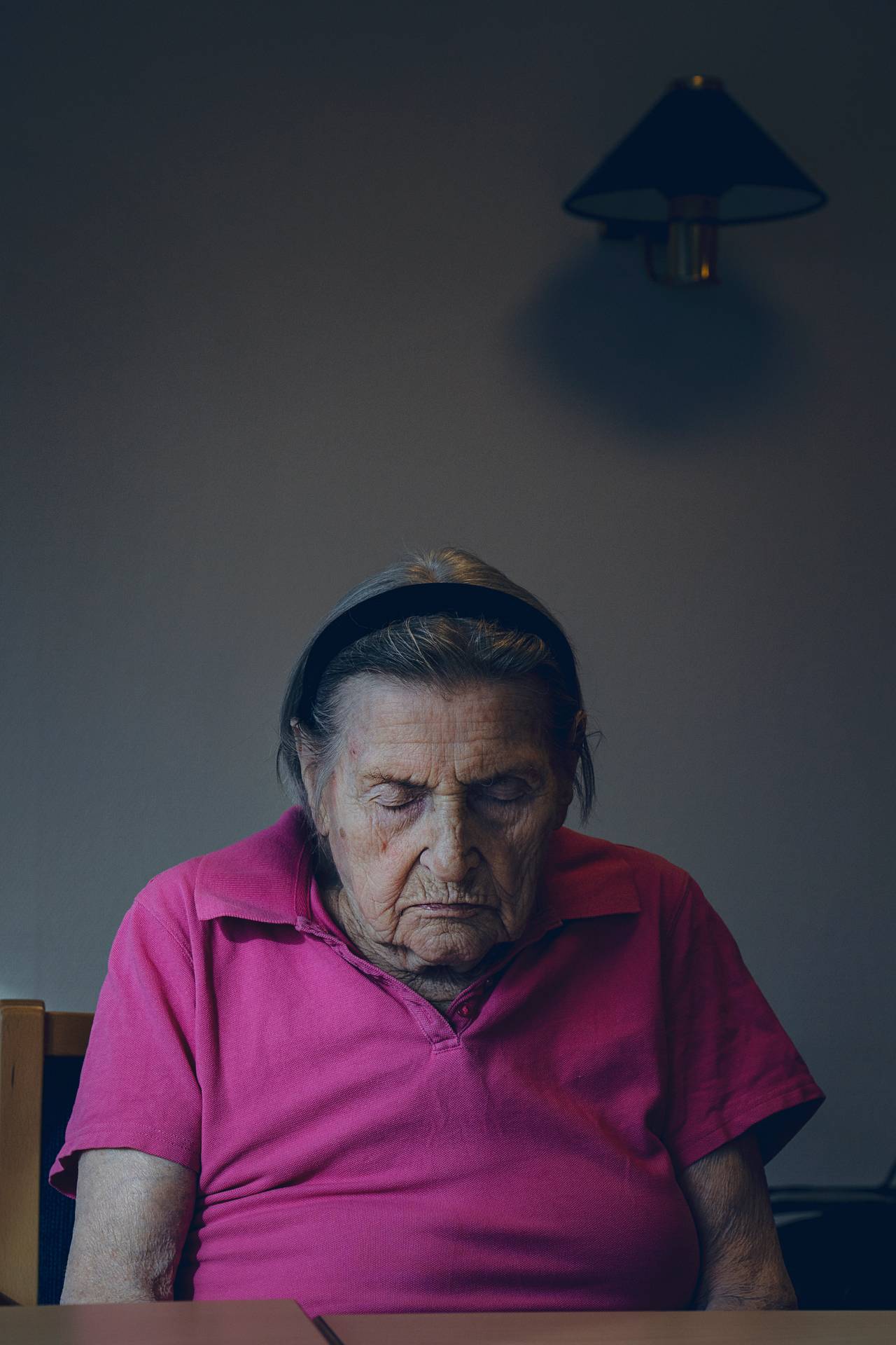 Eugenia sitter foroverlent i en rosa t-skjorte. Øynene er lukket.