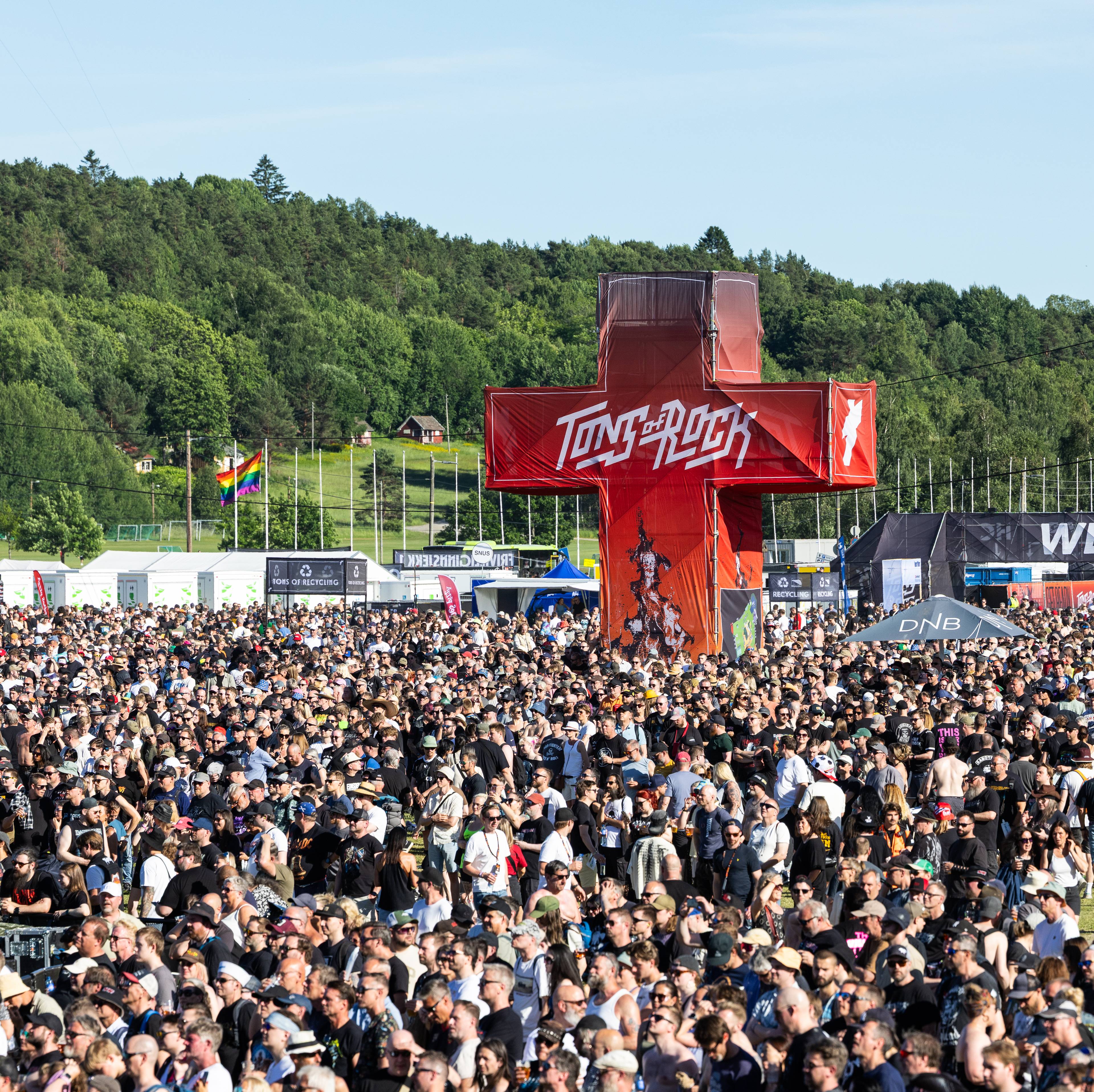 En stor folkemengde er samlet på musikkfestivalen Tons of Rock under åpen himmel. (Bildebeskrivelsen er laget av en KI-tjeneste)