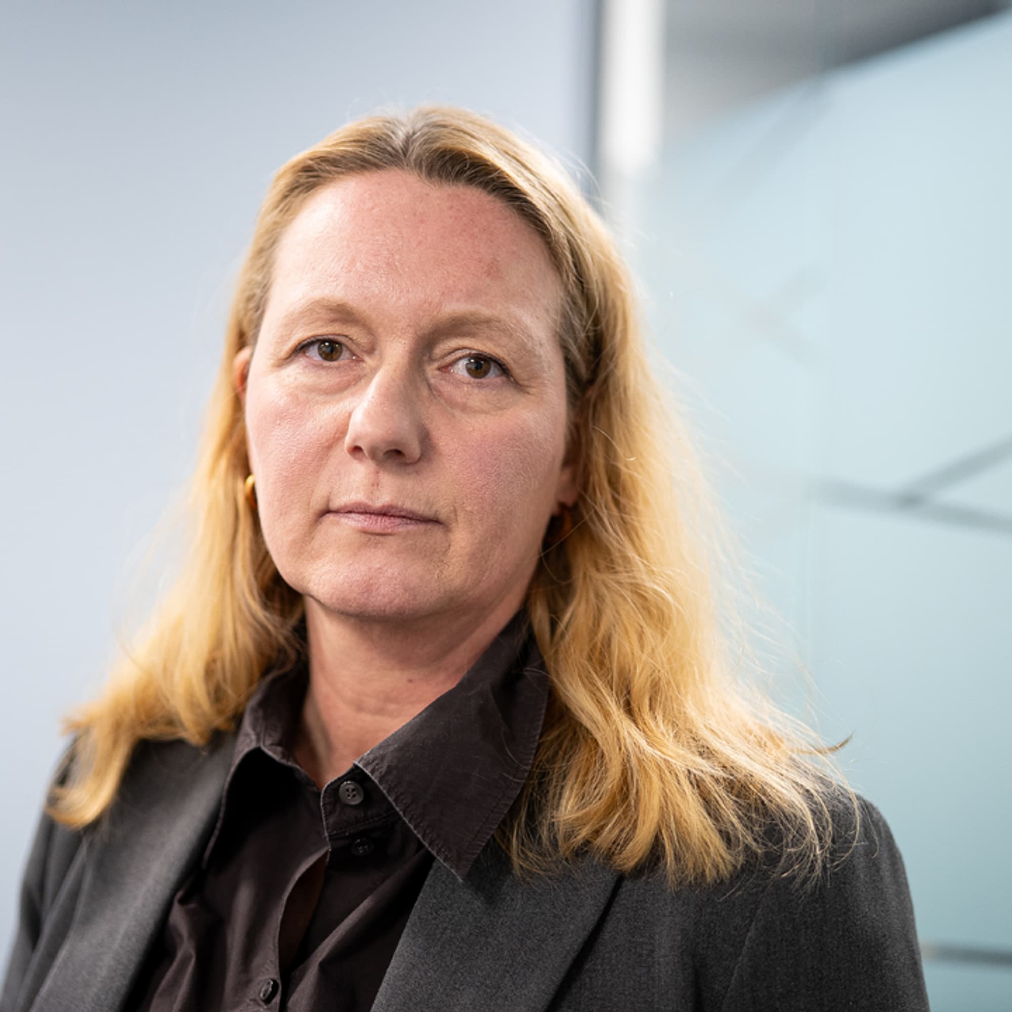 Kvinne med langt lyst hår, mørk dressjakke