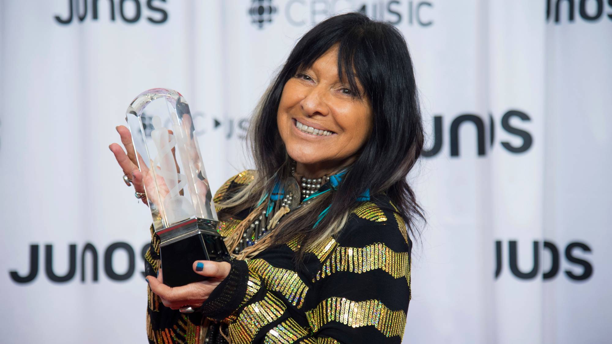 Buffy SaintMarie holder opp en pris for årets utfolksmusikkalbum under Juno Galla Dinner og Awars show i 2018.