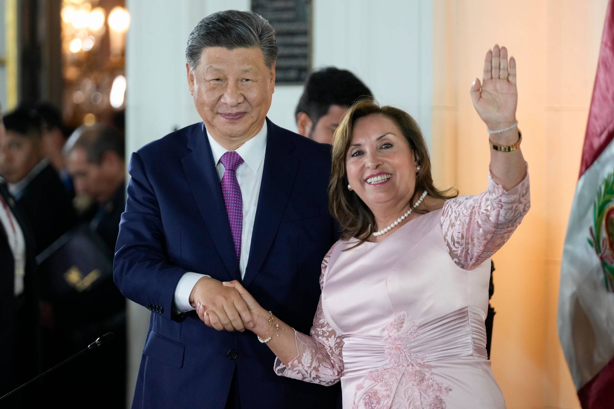Xi Jinping og Perus tidligere president Dina Boluarte håndhilser og vinker. 
