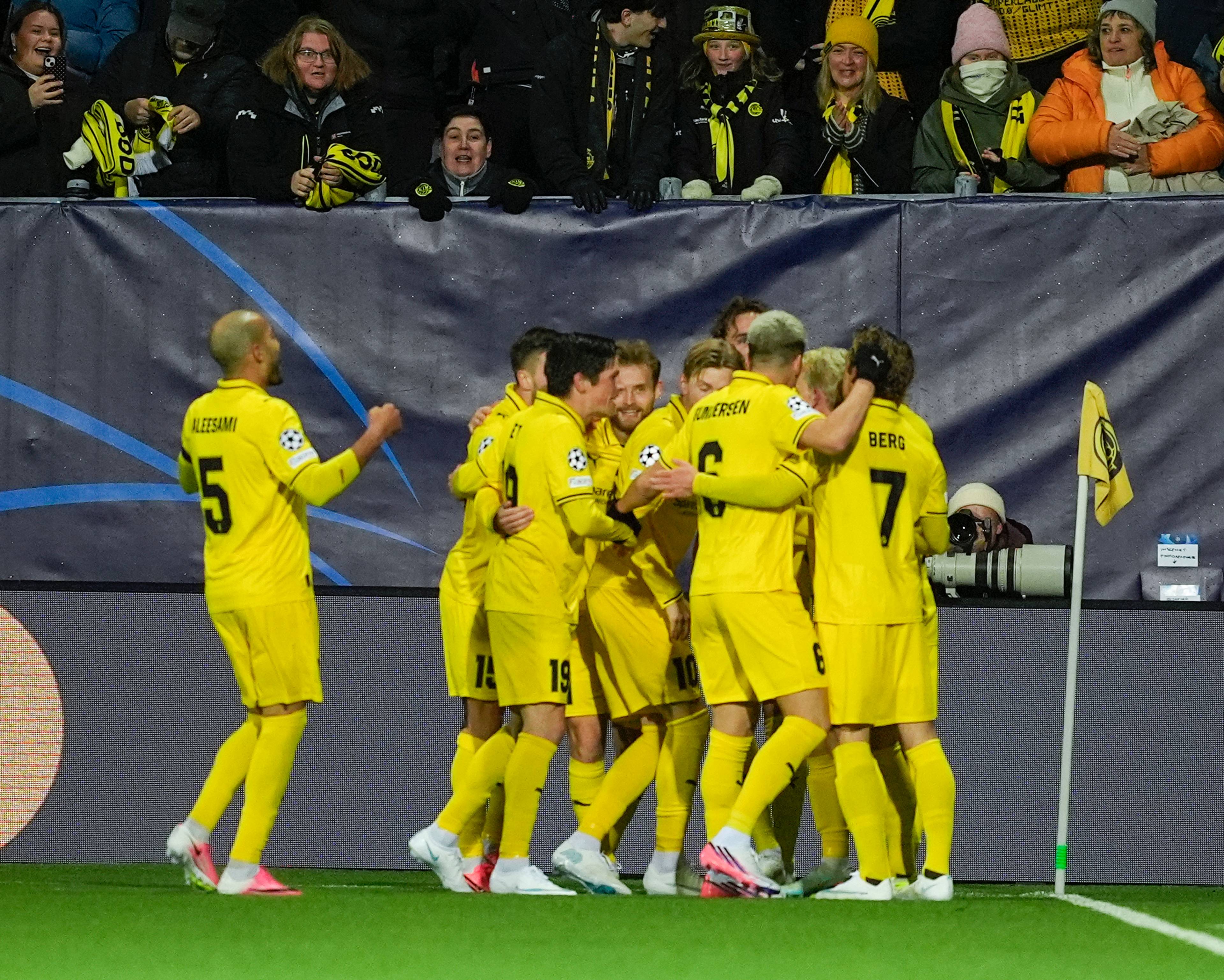 Bodø/Glimt-spillere feirer et mål foran egne supportere på en fotballstadion. (Bildebeskrivelsen er laget av en KI-tjeneste)