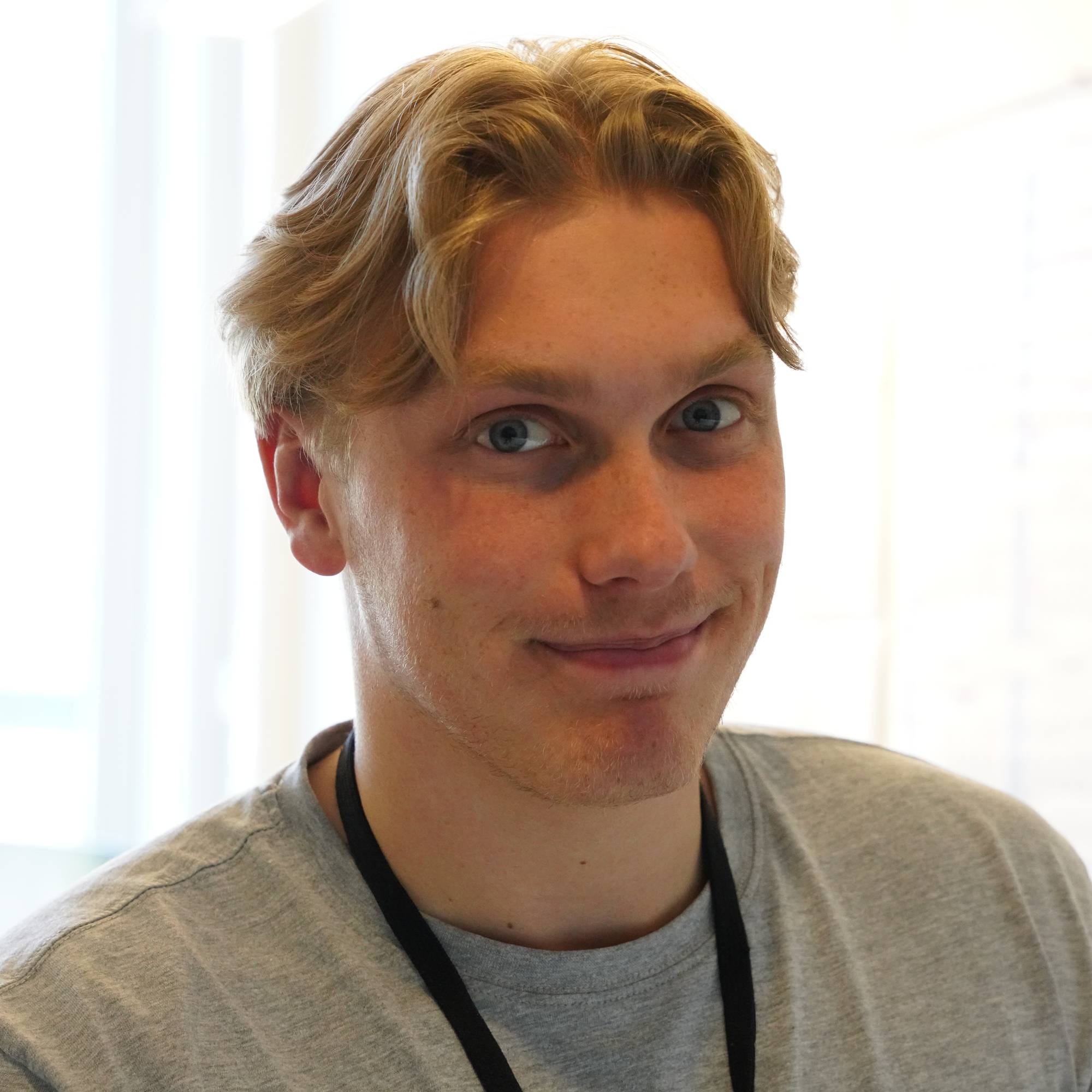  Fredrik Kristoffersen Granstad ser inn i kameraet. Han har blond hår. På seg har han en grå t-skjorte 