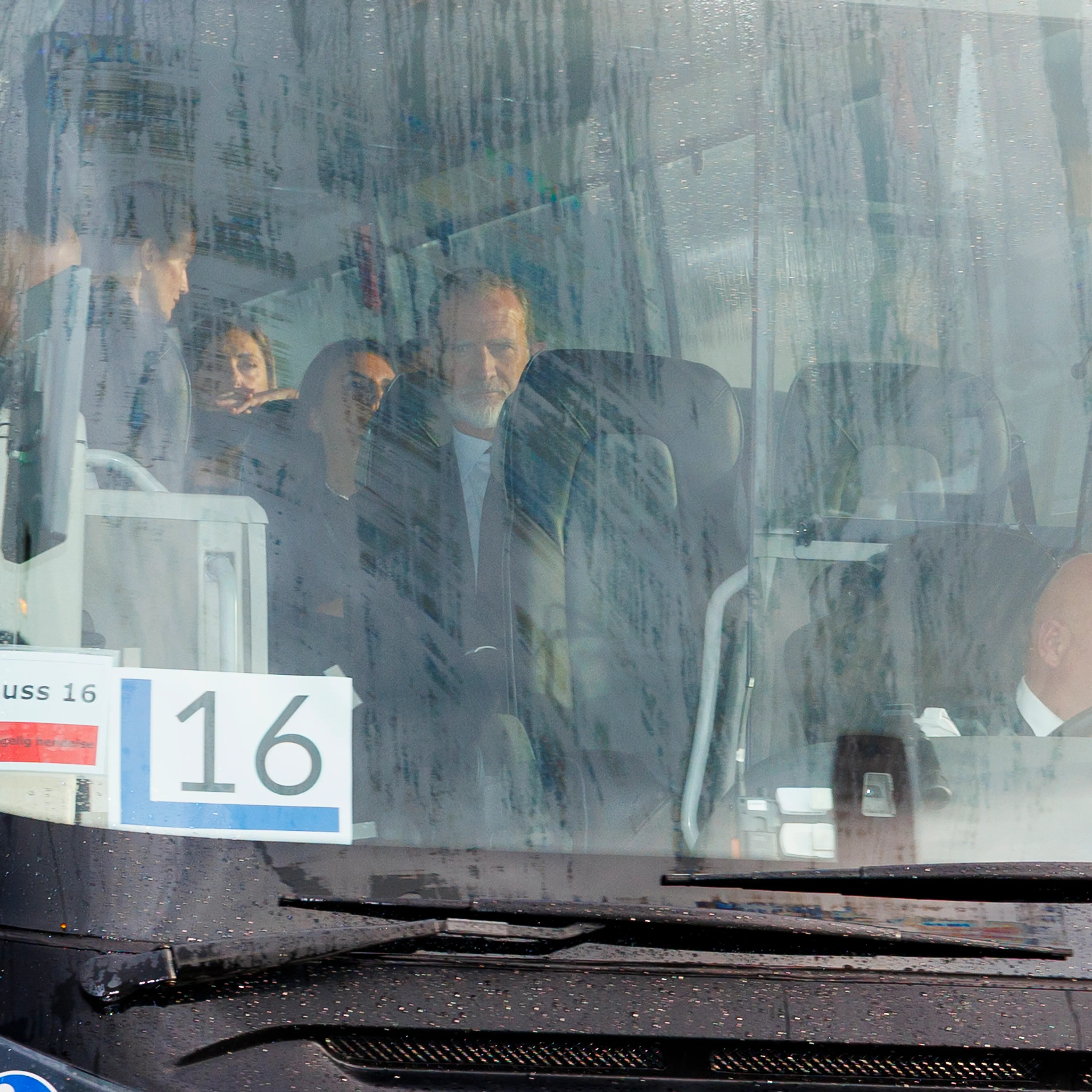 Kong Felipe VI og andre personer sitter i en buss med nummer 16. Sjåføren styrer bussen. (Bildebeskrivelsen er laget av en KI-tjeneste)