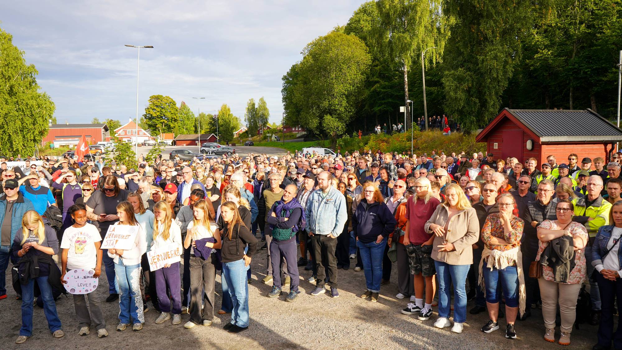 Stor folkemengde samlet til demonstrasjon utendørs med plakater om å bevare Jernverket. (Bildebeskrivelsen er laget av en KI-tjeneste)