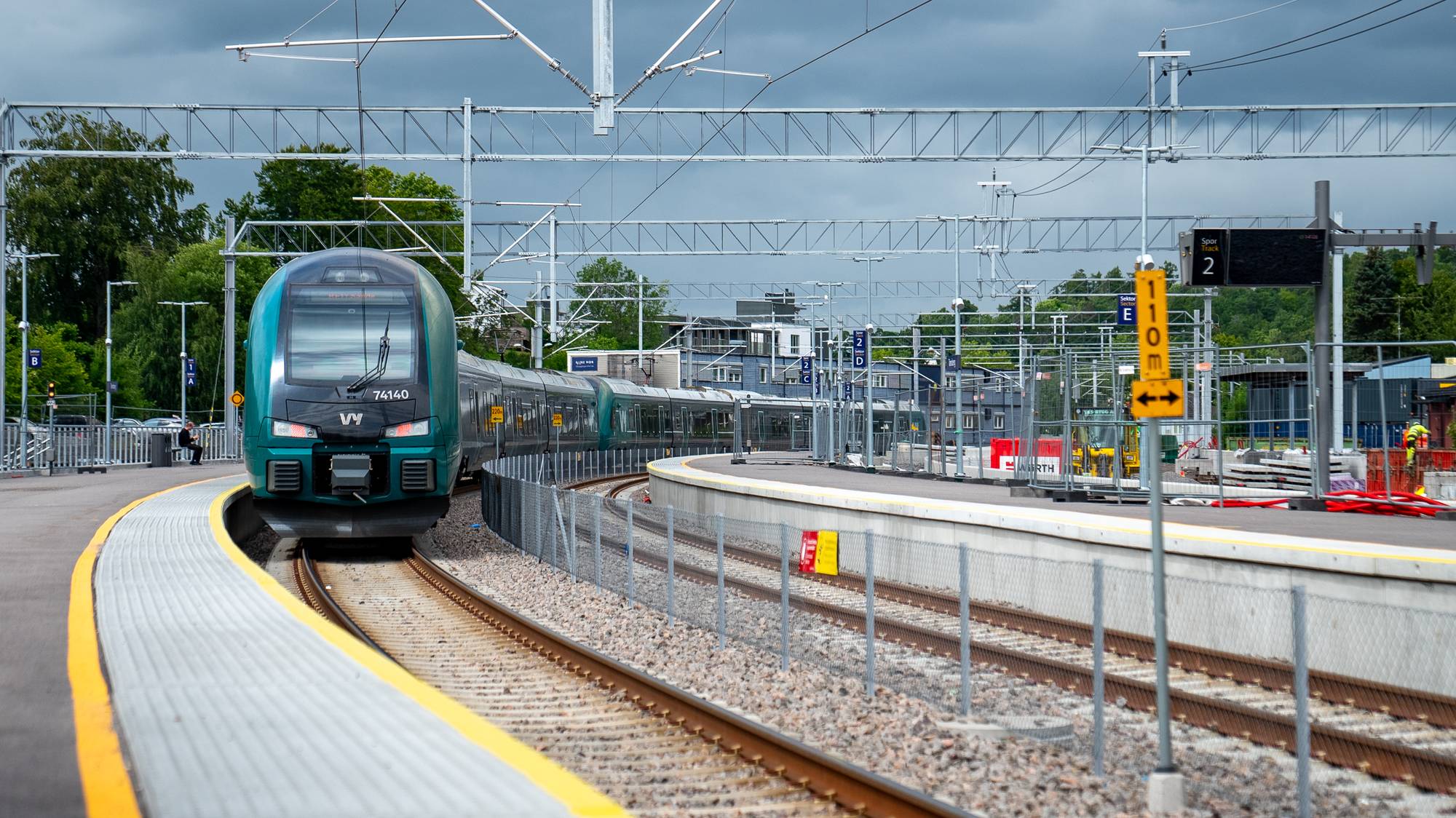 Et grønt og sort Vy-tog nærmer seg perrongen på Tønsberg stasjon.