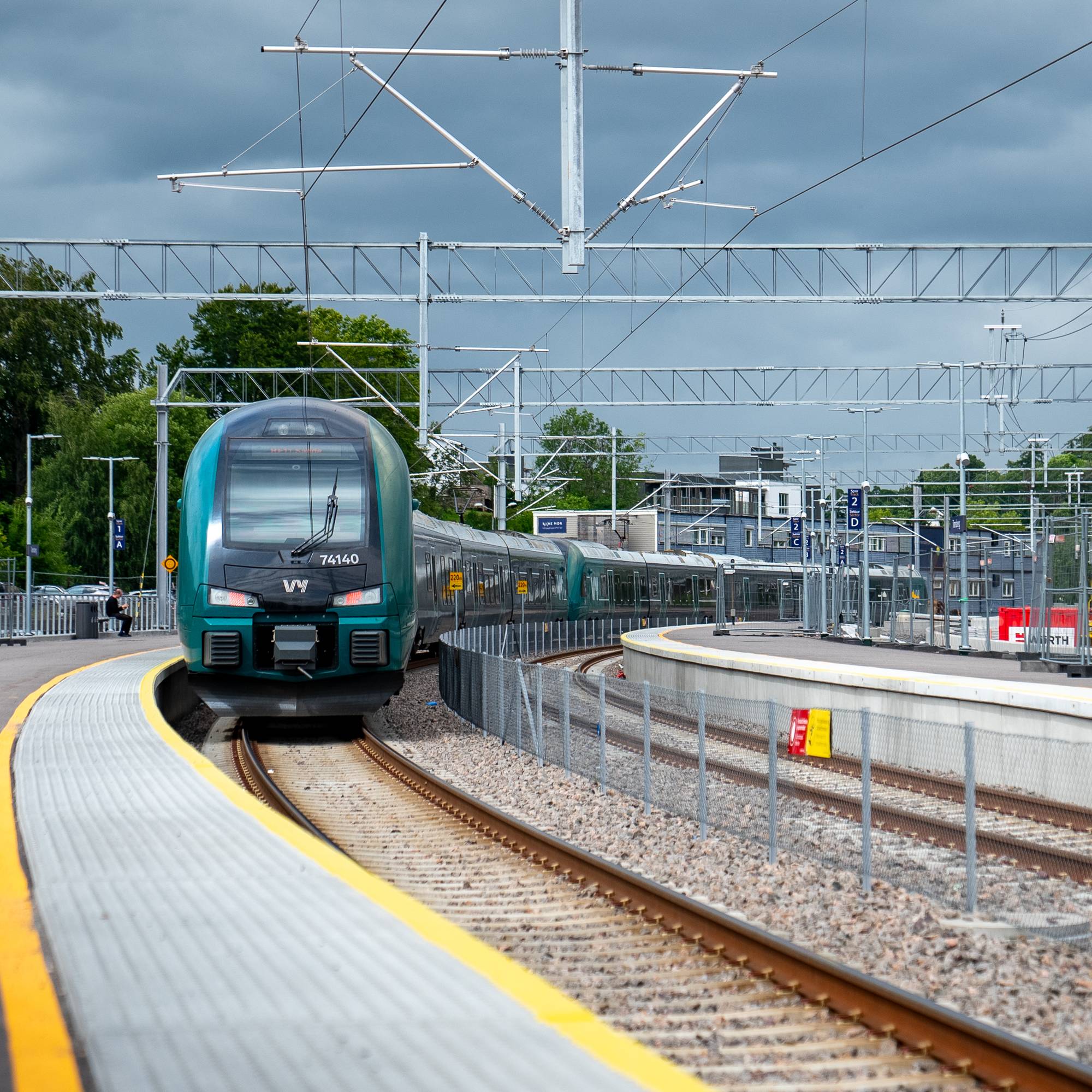 Et grønt og sort Vy-tog nærmer seg perrongen på Tønsberg stasjon.
