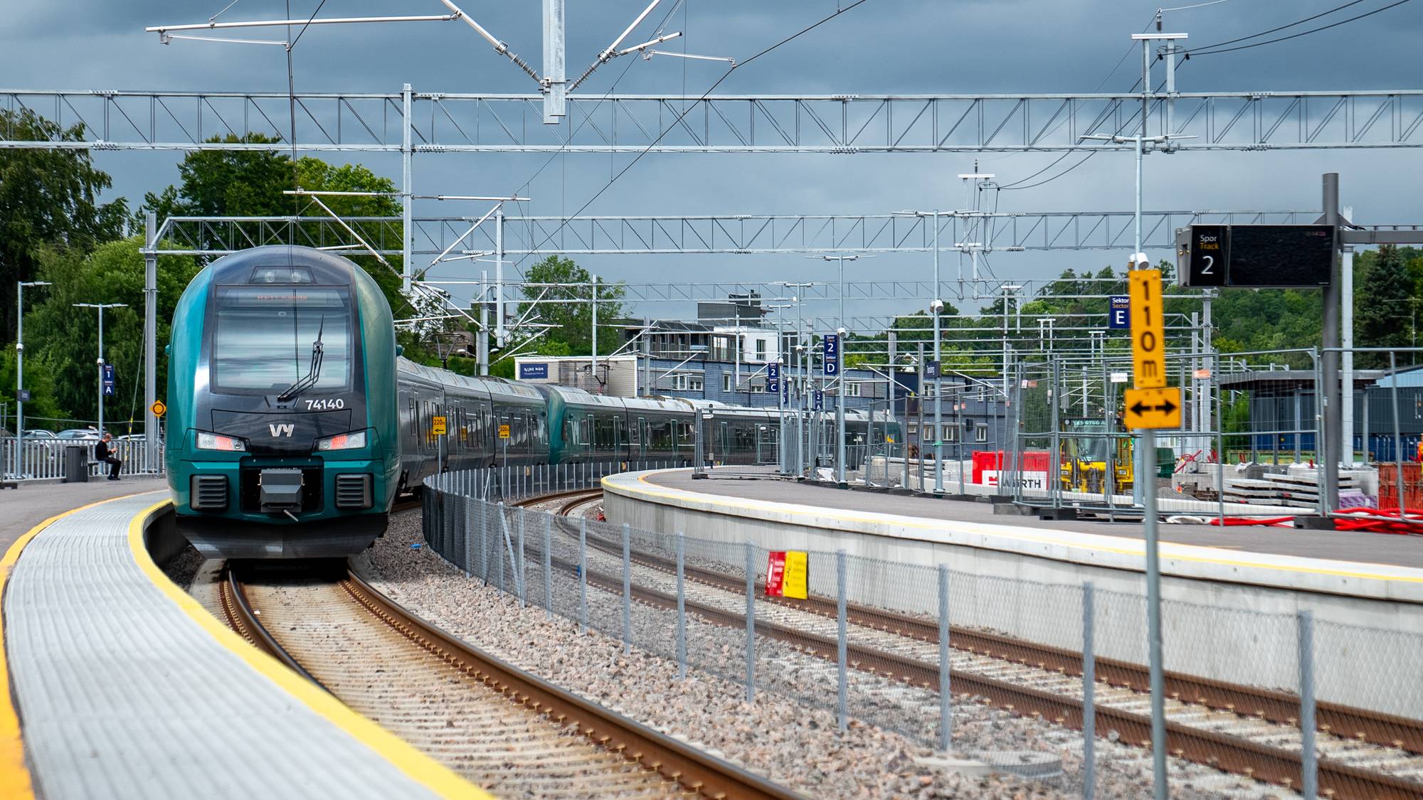 Et grønt og sort Vy-tog nærmer seg perrongen på Tønsberg stasjon.