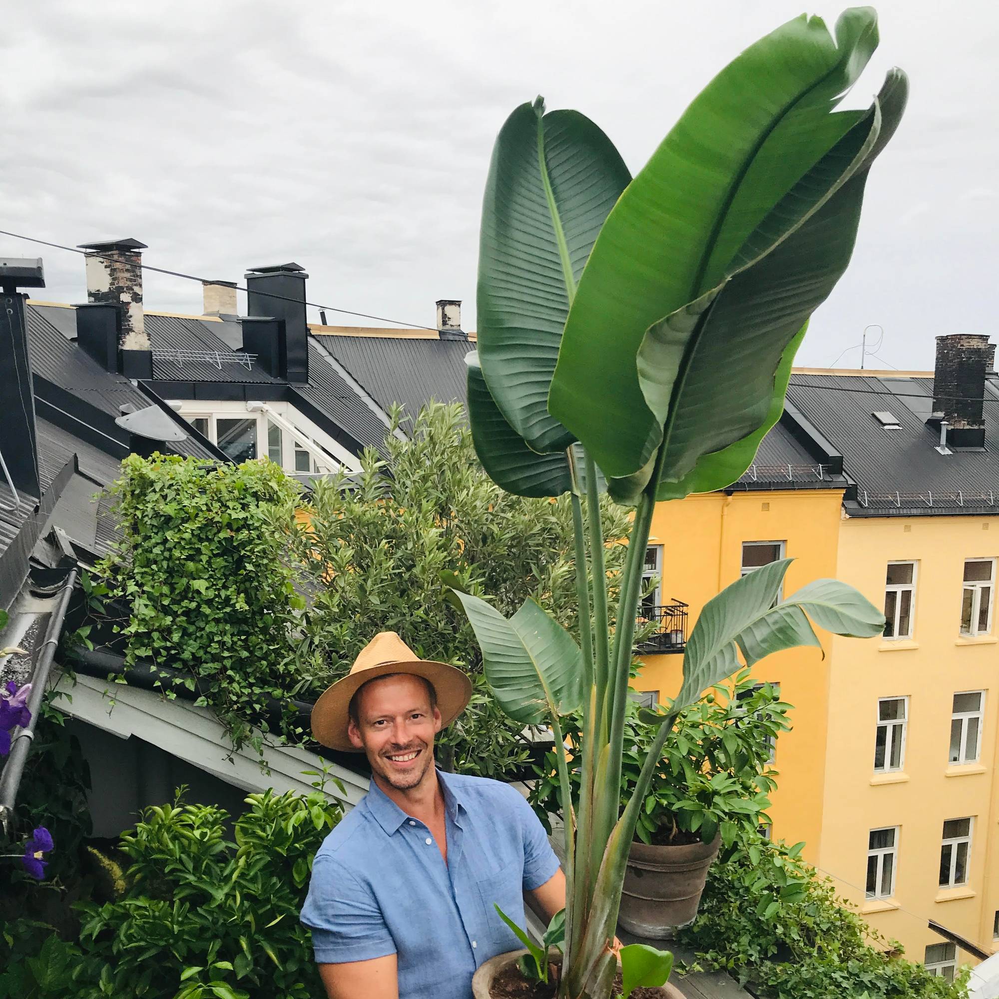 Anders Røyneberg holder en stor plante på verandaen sin