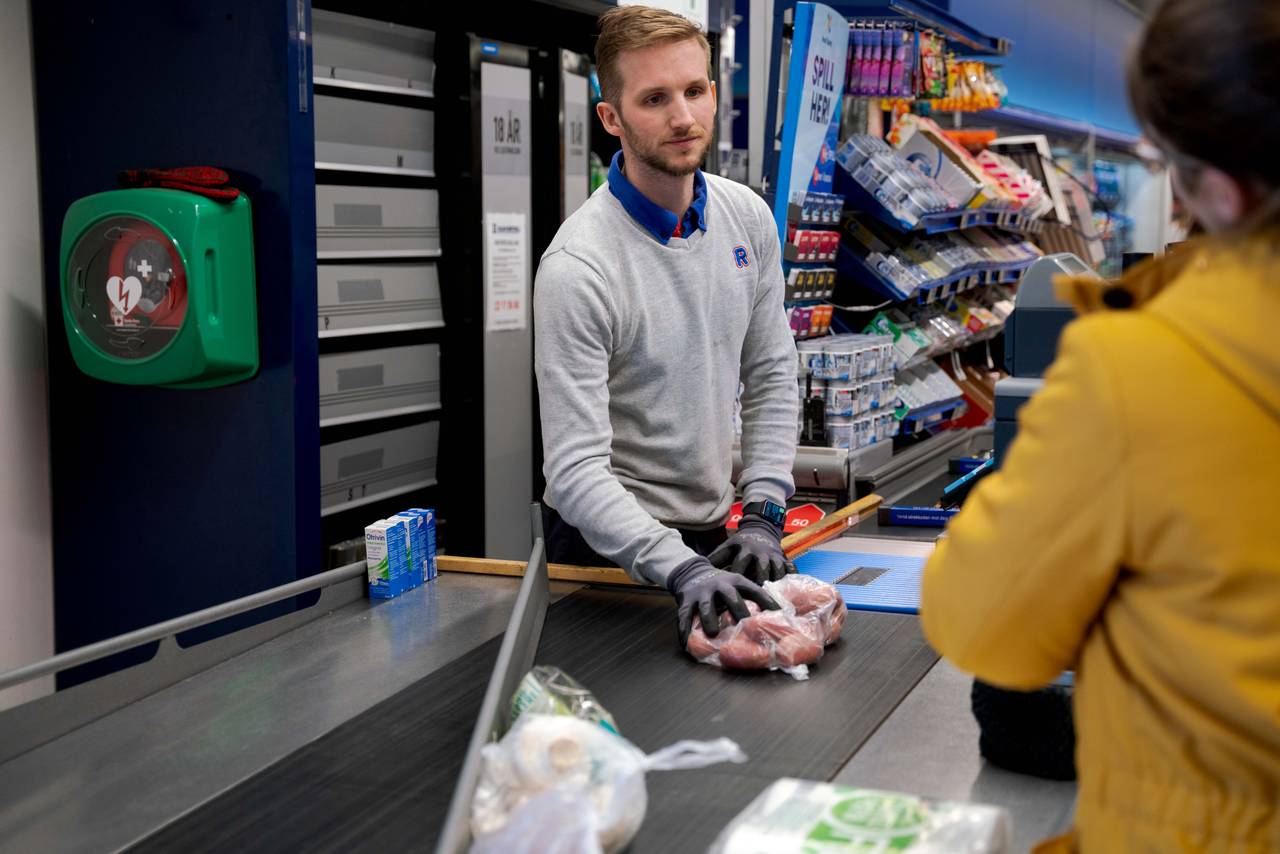 Butikkmedarbeider Christian Hartz betjener kunde på Rema 1000 på Ensjø.