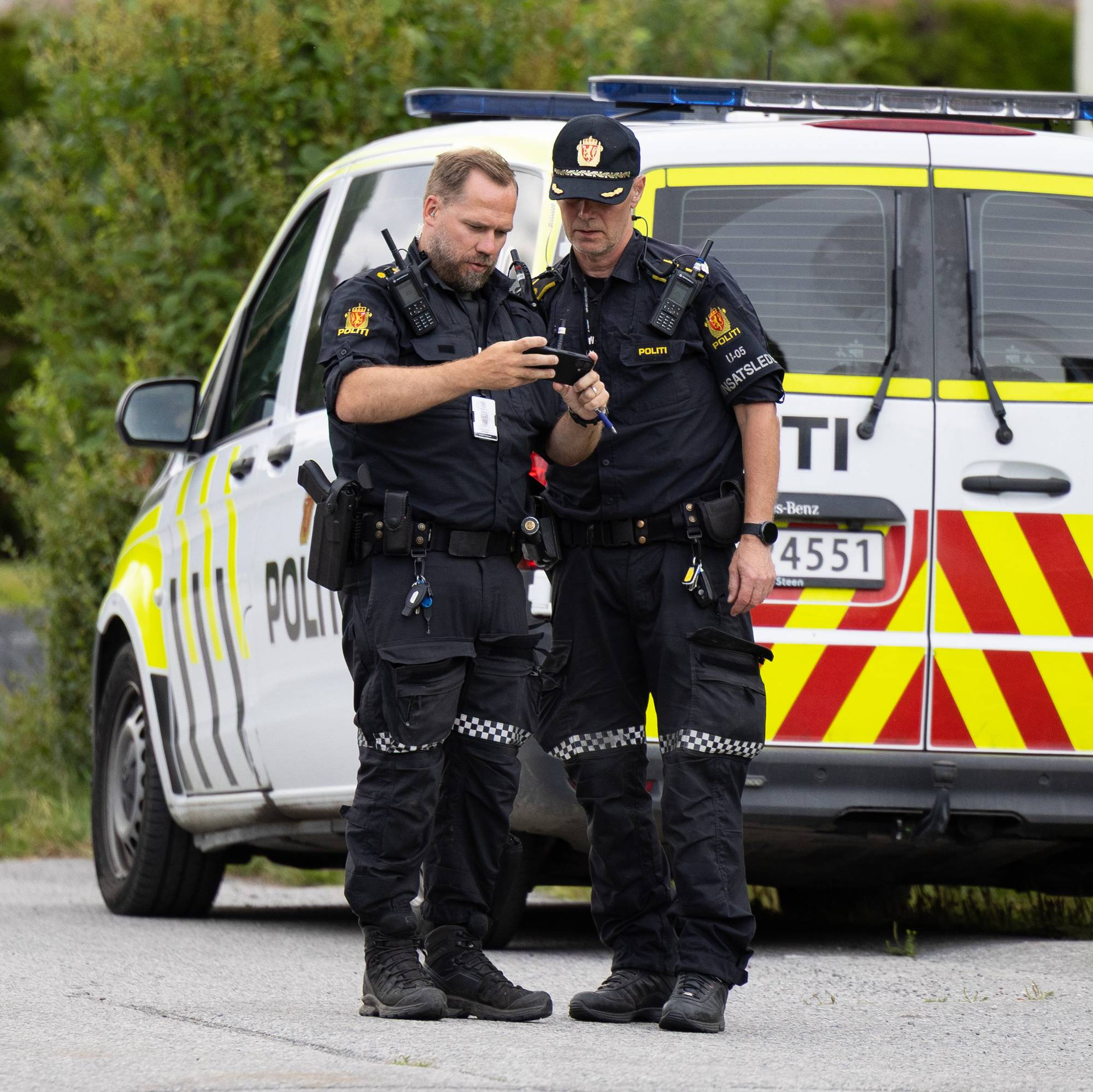 To politipatruljer som står ute bak en politibil. 