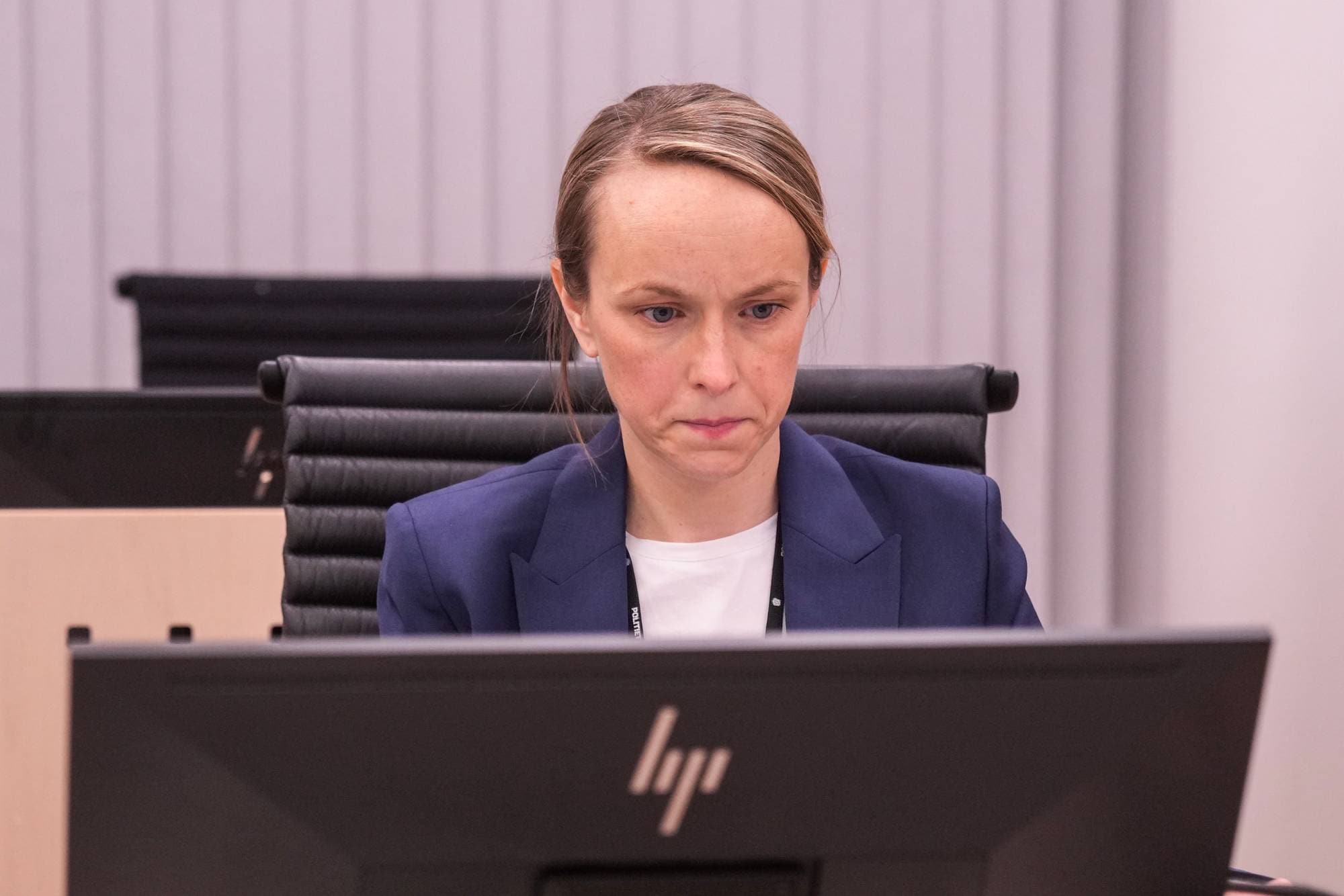 En kvinne sitter ved en datamaskin i et kontorlandskap og ser ned på skjermen. (Bildebeskrivelsen er laget av en KI-tjeneste)