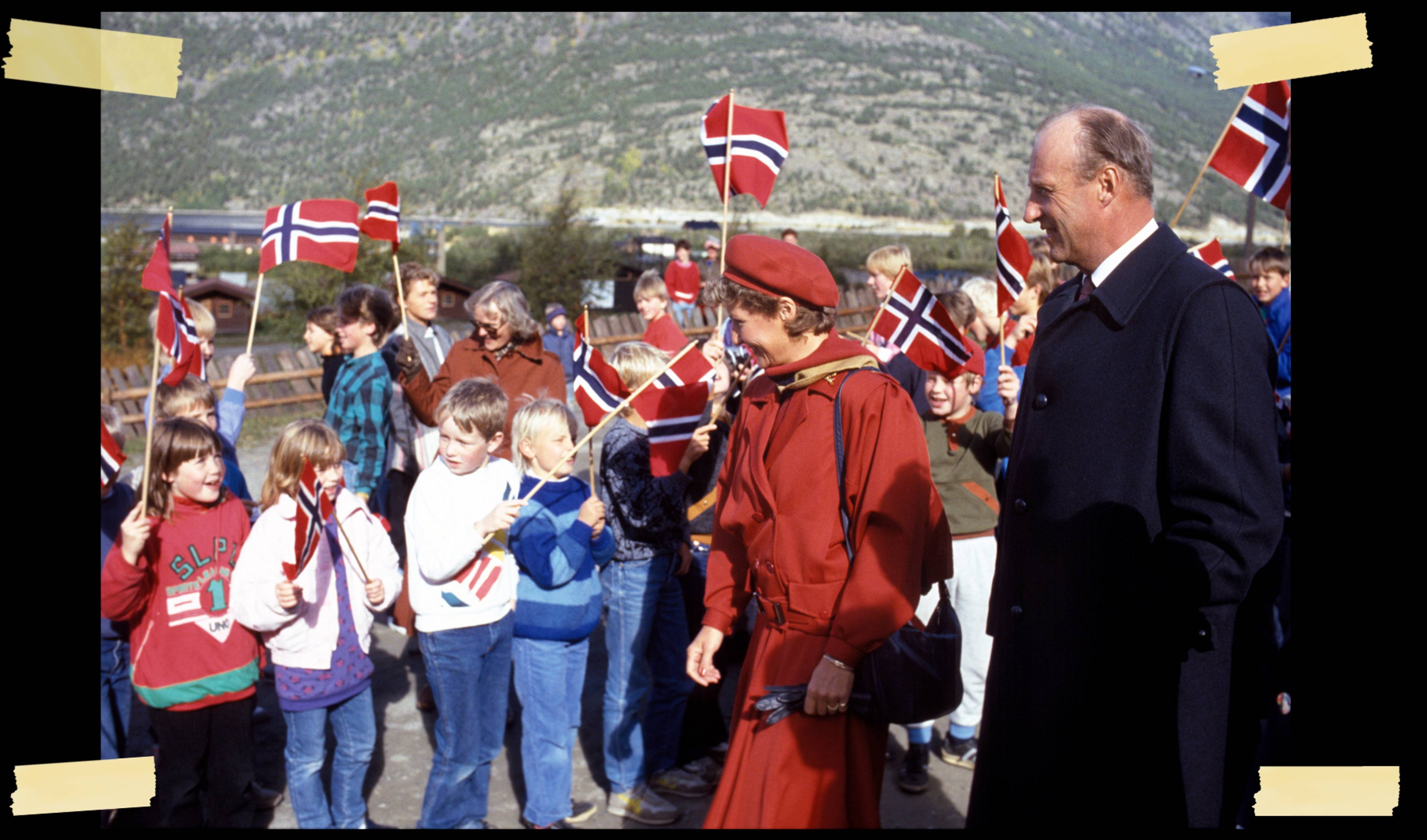 Kronprinsparet møter barn som hilser dem med flagg.