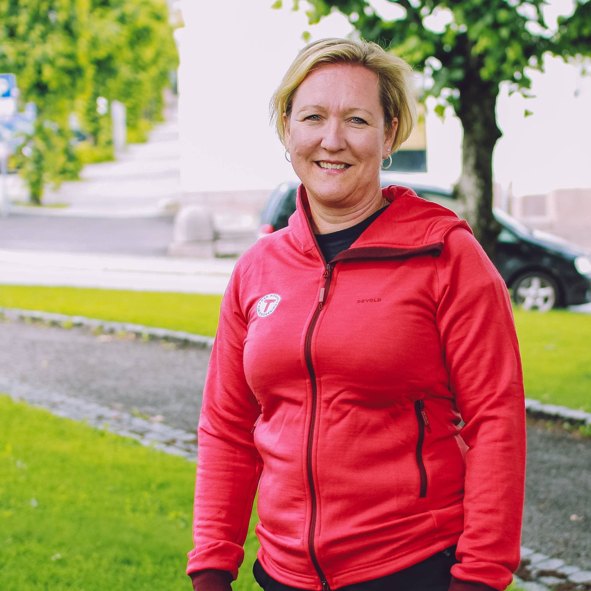 Bildet viser en kvinne i rød DNT-jakke