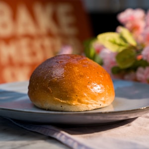 Et gyllen hvetebolle ligger på en tallerken.