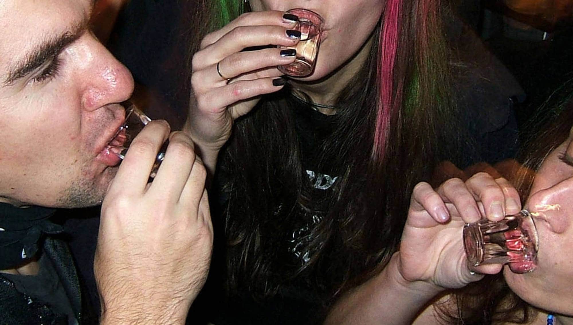 Tre personer drikker vodkashots i Praha