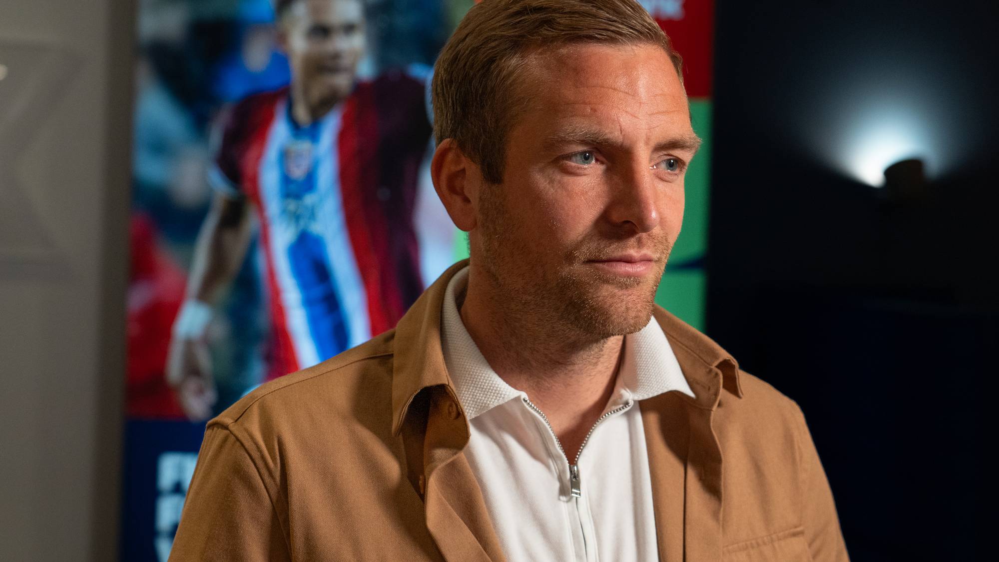 Kristoffer Lie Løkberg med en VM-plakat i bakgrunnen
